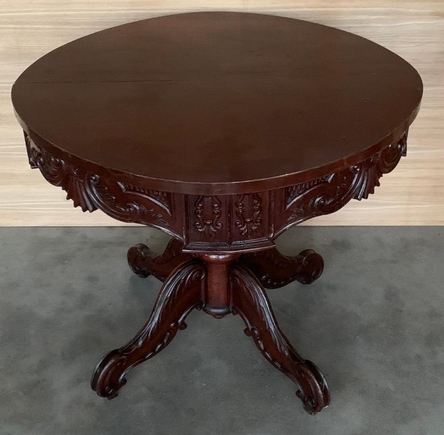 Ancienne table centrale / table à déjeuner en acajou d'époque Biedermeier française du début du 19e siècle, de forme ronde avec tablier sculpté, soutenue par une colonne tournée et sculptée sur une base triangulaire. Circa 1830s.-1900
C'est ce que