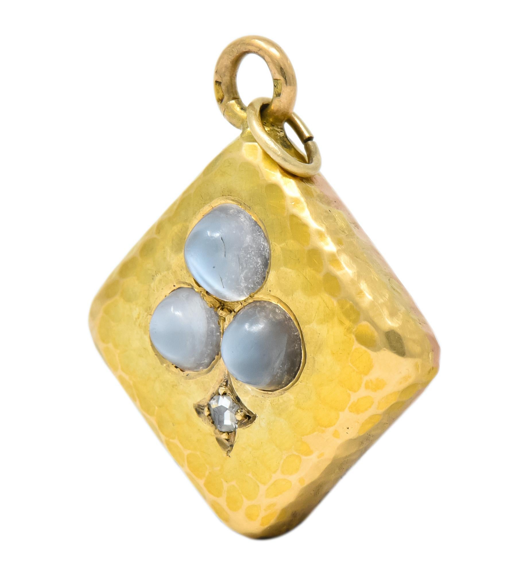 Featuring a square form foundation of mixed finish 18 karat gold with a dimpled surface and bezel set cabochon moonstones in a Spades motif

With a bead set rose cut diamond, eye-clean and white

Completed by a round bale with French assay