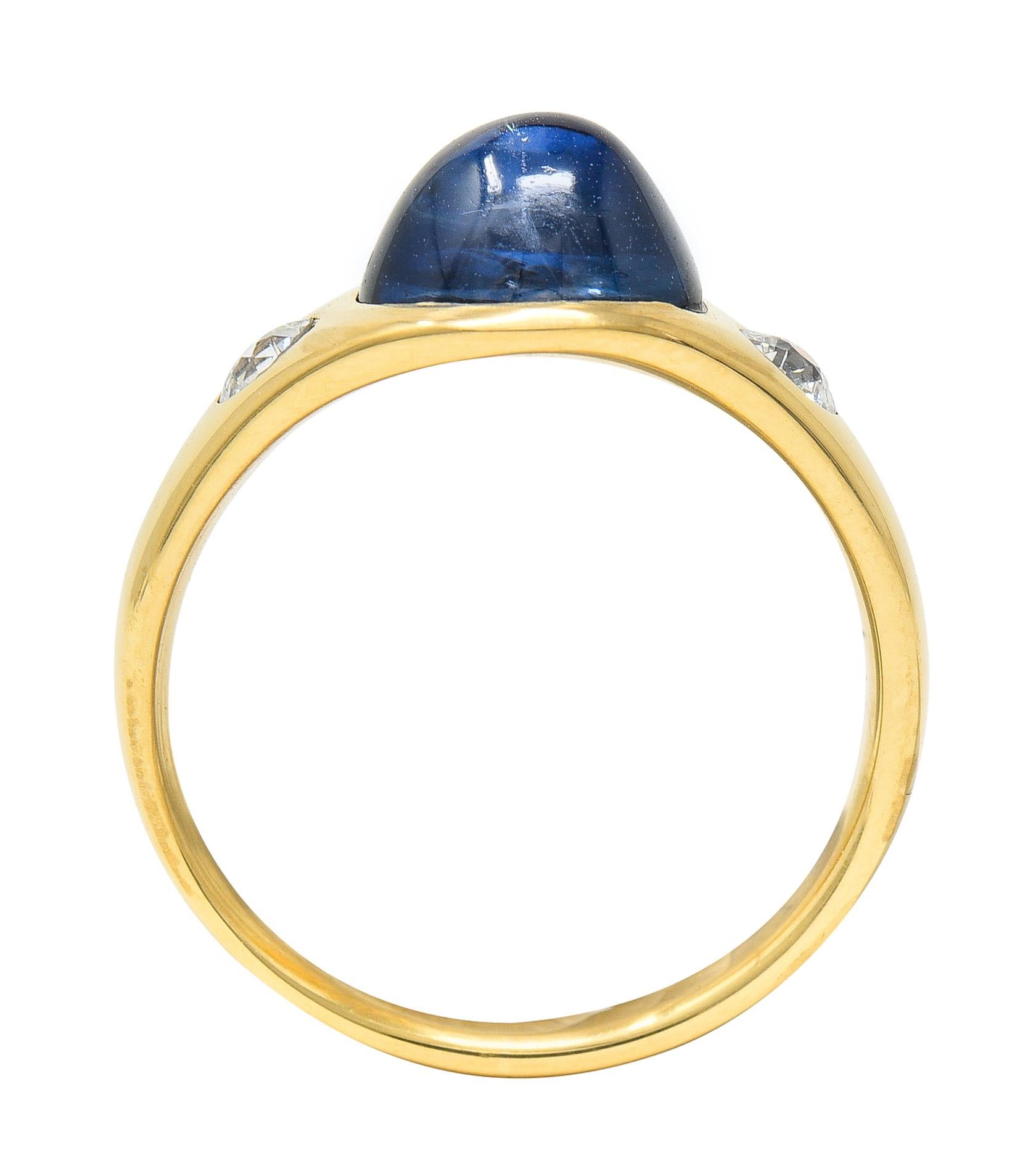 Gypsy band ring features a highly domed Ceylon sapphire cabochon weighing approximately 3.25 carats. Blue in color with no indications of heat - Sri Lankan in origin. Flanked by two flush set old European cut diamonds. Weighing collectively