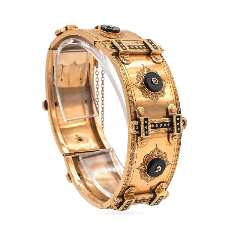 A super quality French Victorian Cuff Bracelet. Composed of 18k yellow gold. Featuring 6 black onyx discs on the panels, topped with rose cut diamonds and set between black enameled buckle motifs. With ornately engraved floral details throughout the