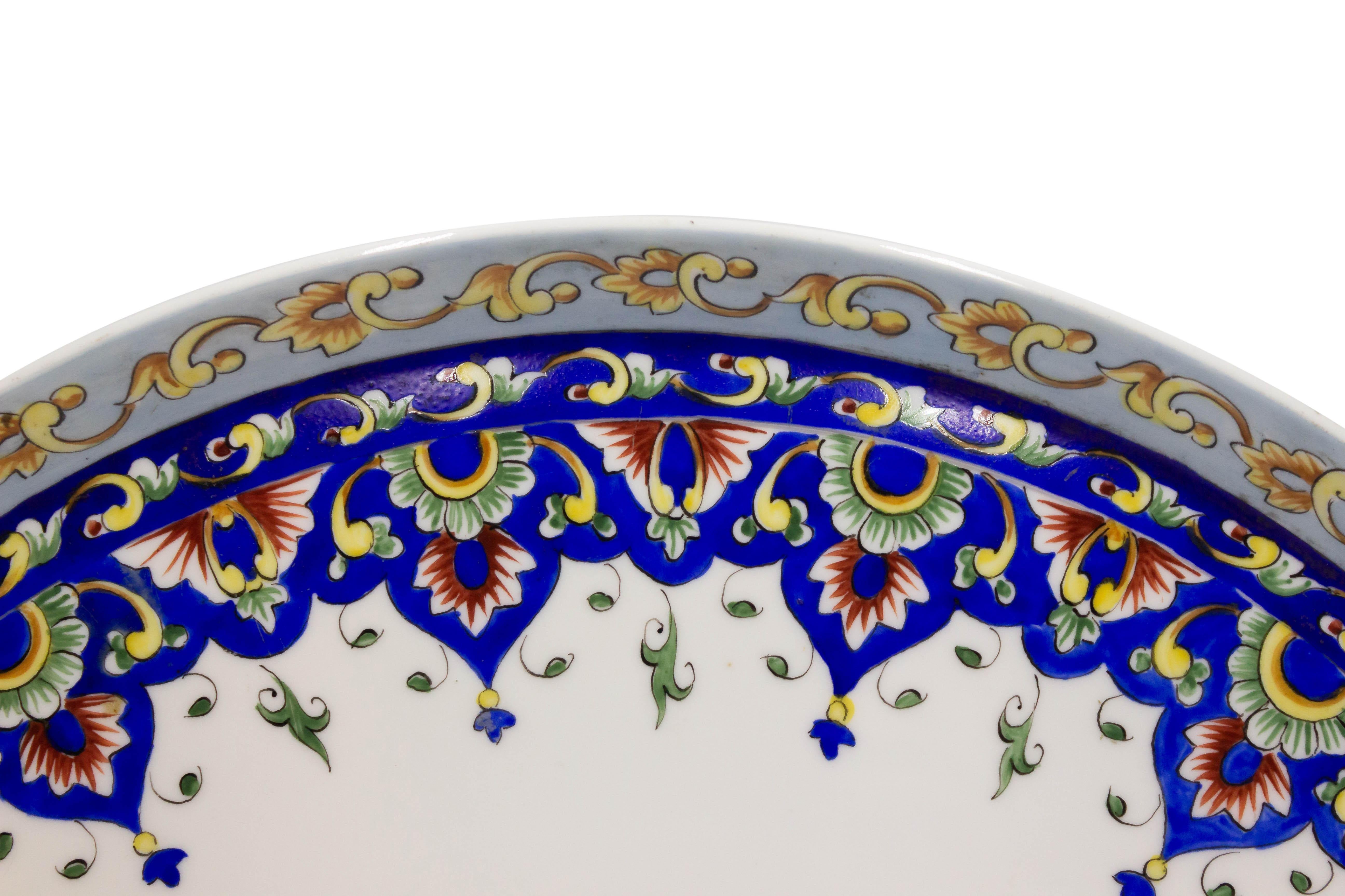 Cargador de porcelana victoriana francesa con borde decorado en amarillo y diseño festoneado azul con flores en el borde.