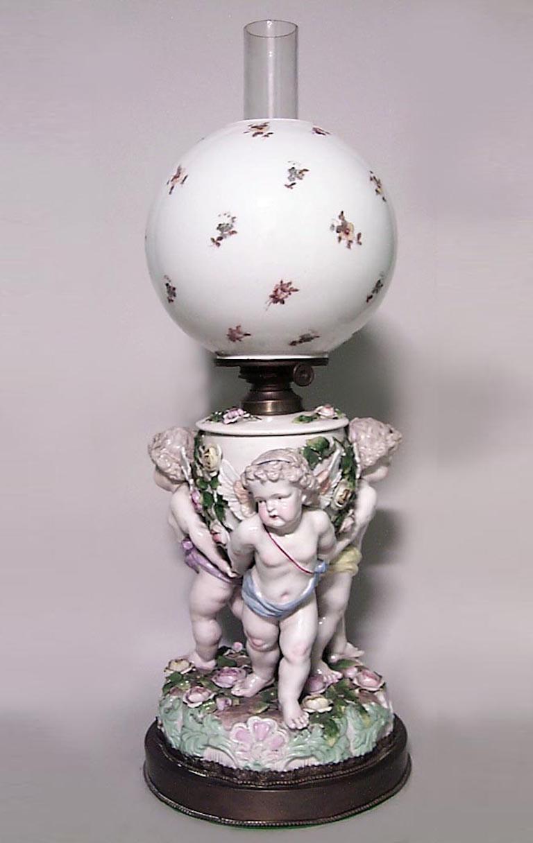 French Victorian porcelain oil lamp with triple cupid base and decorated globe with chimney
