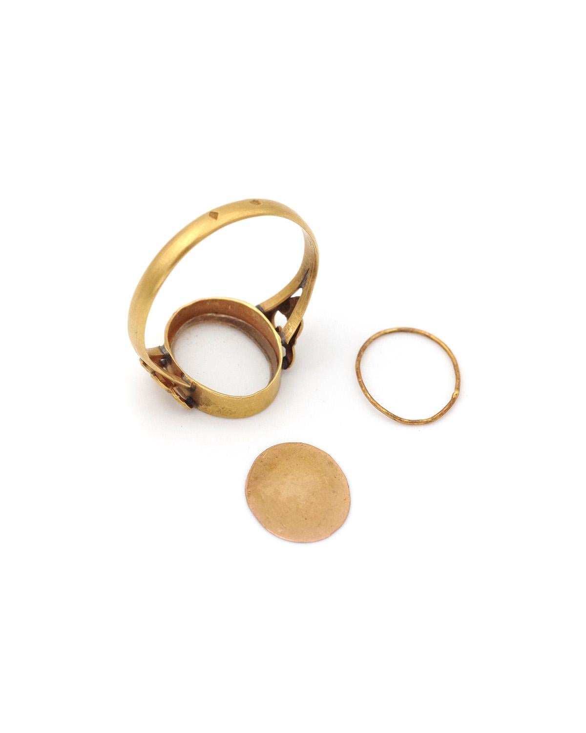 Victorian sentimental locket ring in 18 karat gold. In the center of the ring is an oval compartment protected by glass, the opening of which is located on the reverse. It can be used to slide a portrait, a photo, a flower, or a sentimental object.