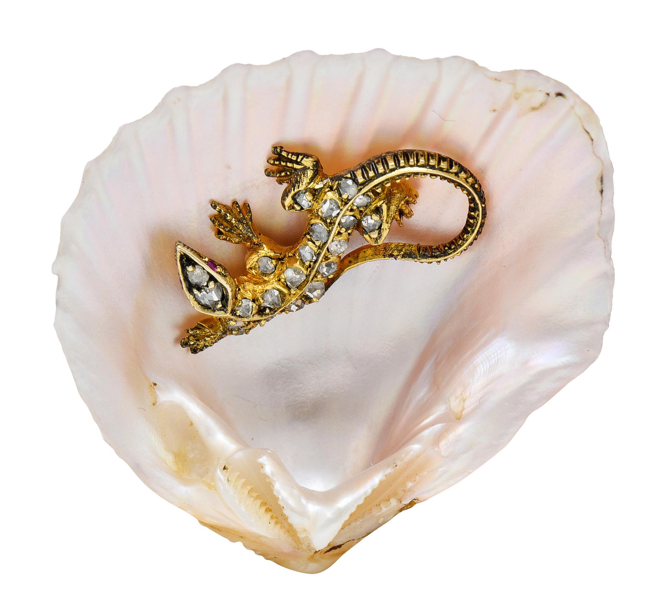 Brooch is designed with a cupped and scalloped shell

Pastel pink in color with strongly iridescent mother-of-pearl

Centering a stylized gold lizard accented by rose cut diamonds - approximately 0.20 carat

A Victorian object of courtship -
