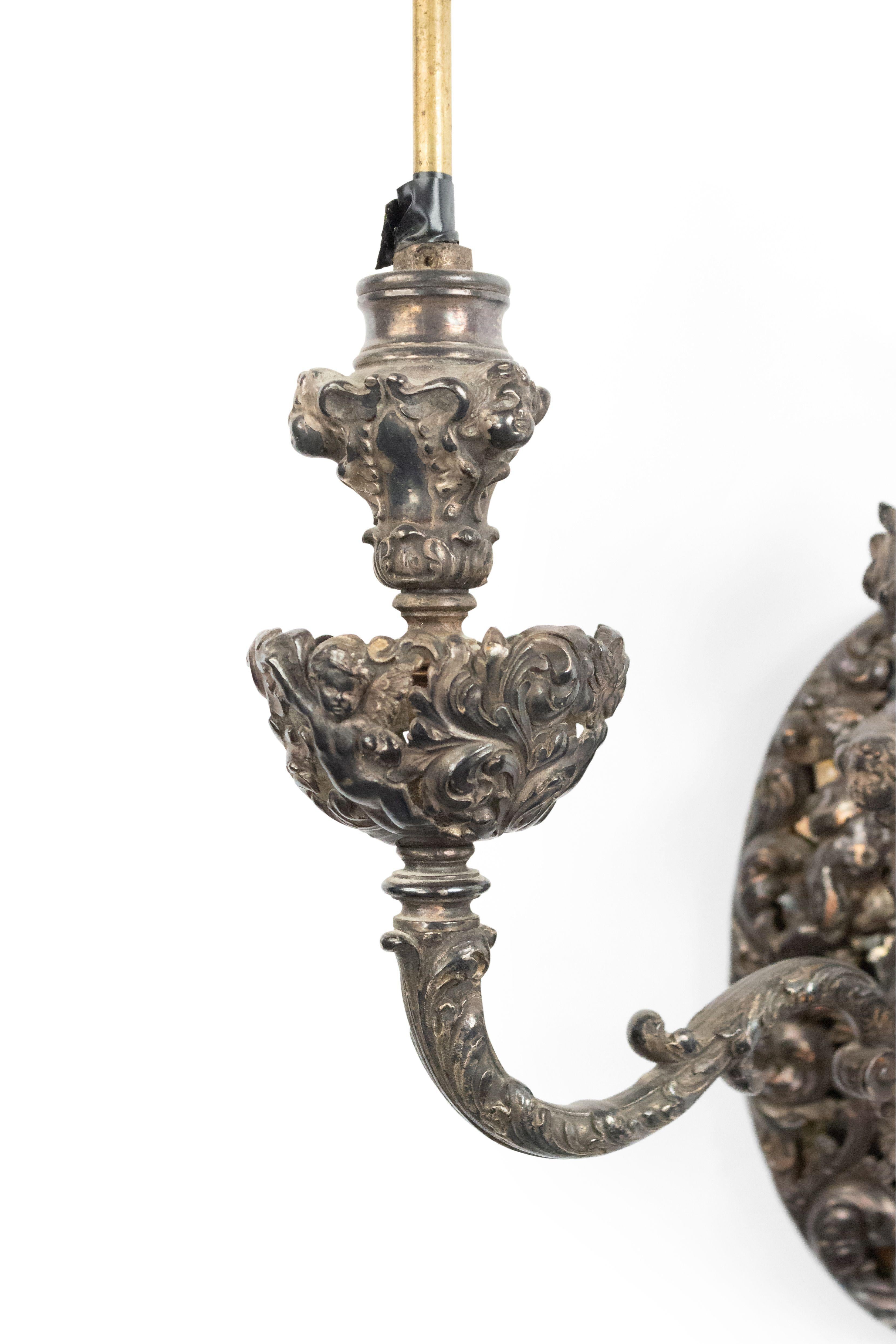 Pair of French Victorian silver plate scroll and filigree 2 arm wall sconces with flame finial top and cupid heads.