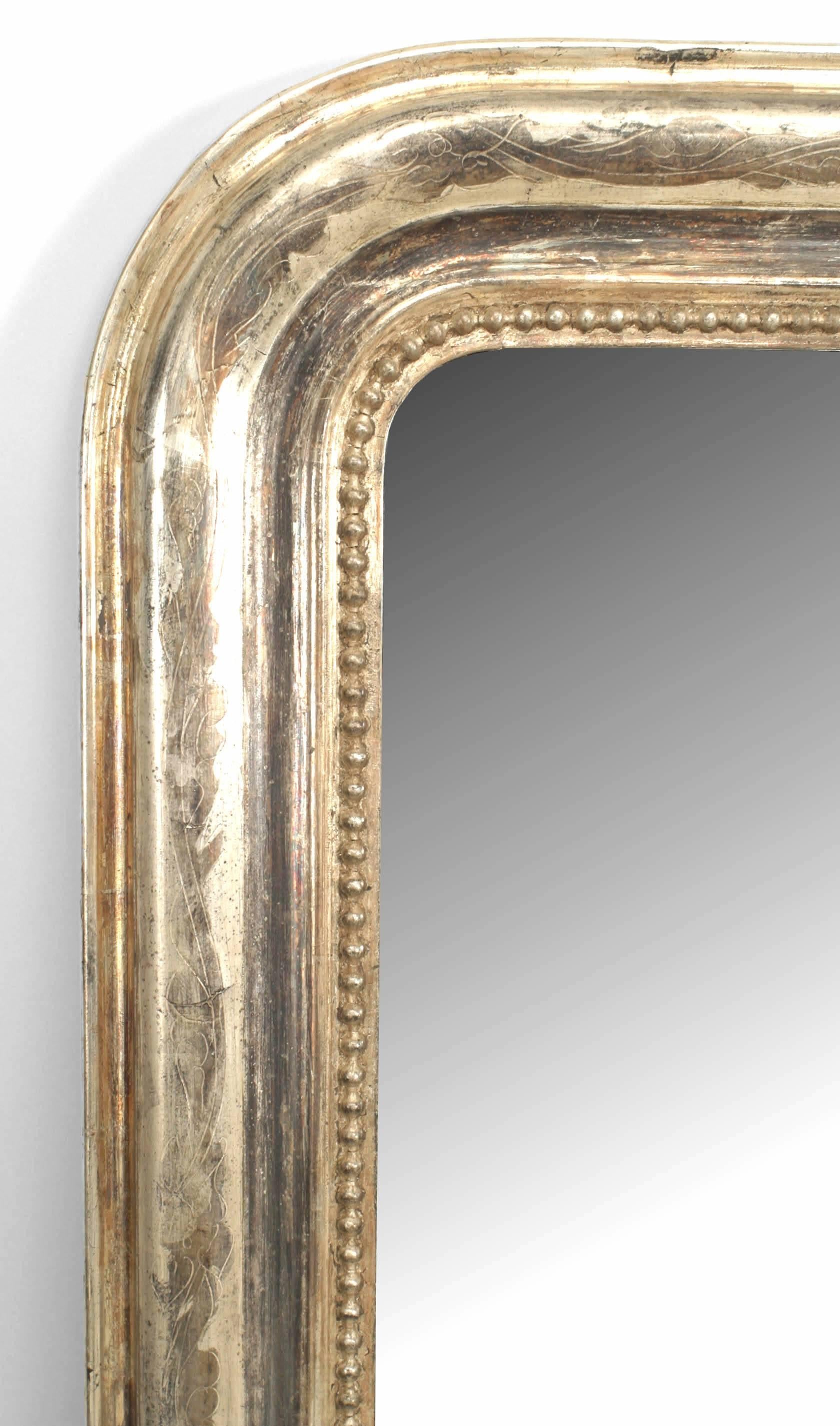 French Victorian style (19th-20th century) silver gilt framed mirror with rounded top sides and burnished silver floral design with beaded trim around mirror.
   