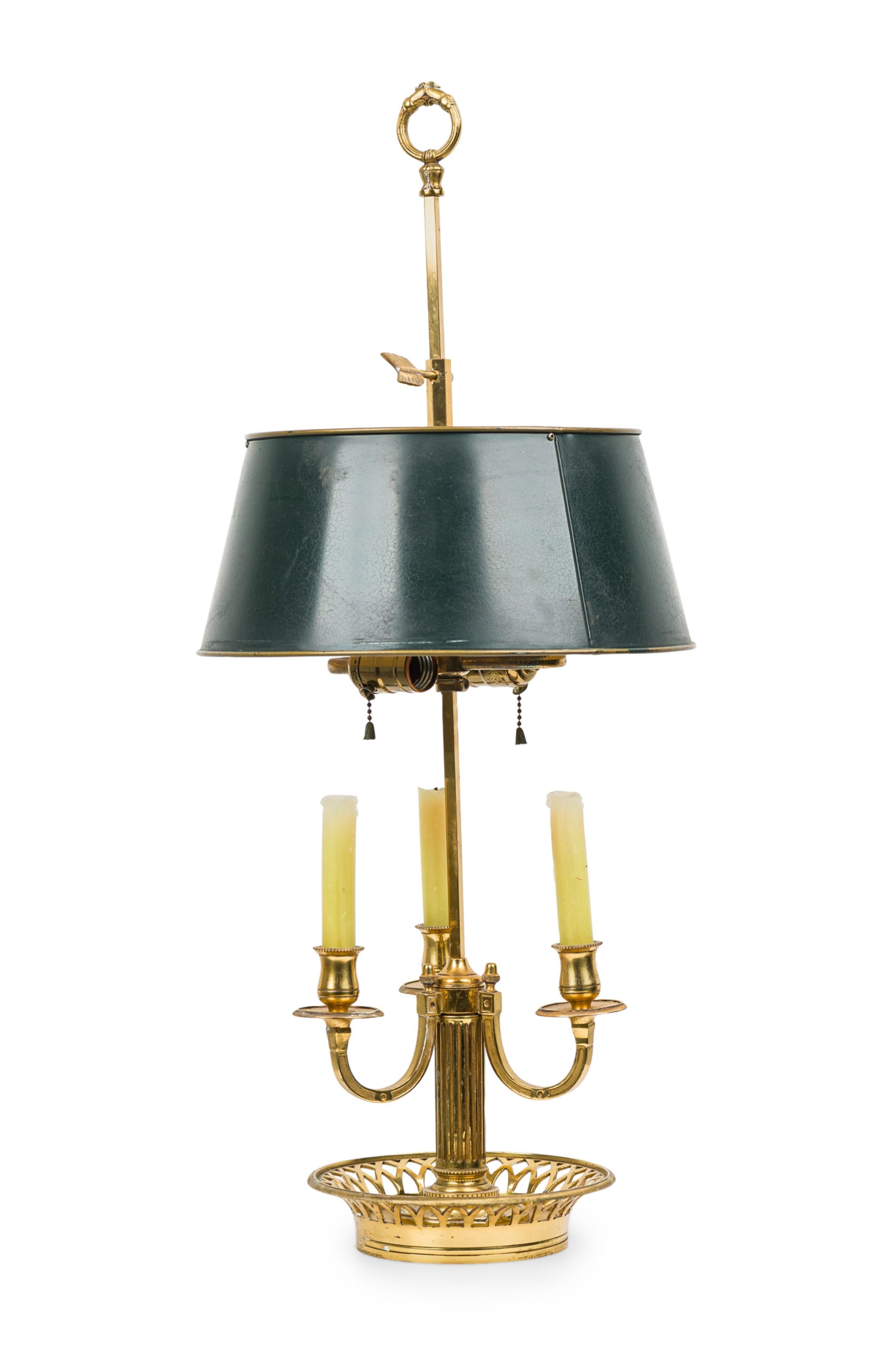 Lampe de table en laiton bouilotte de style victorien, composée d'une haute tige rectangulaire étroite couronnée d'un anneau à volutes amovible, surmontant un abat-jour conique en métal vert dissimulant deux douilles en forme de S, suivi de trois