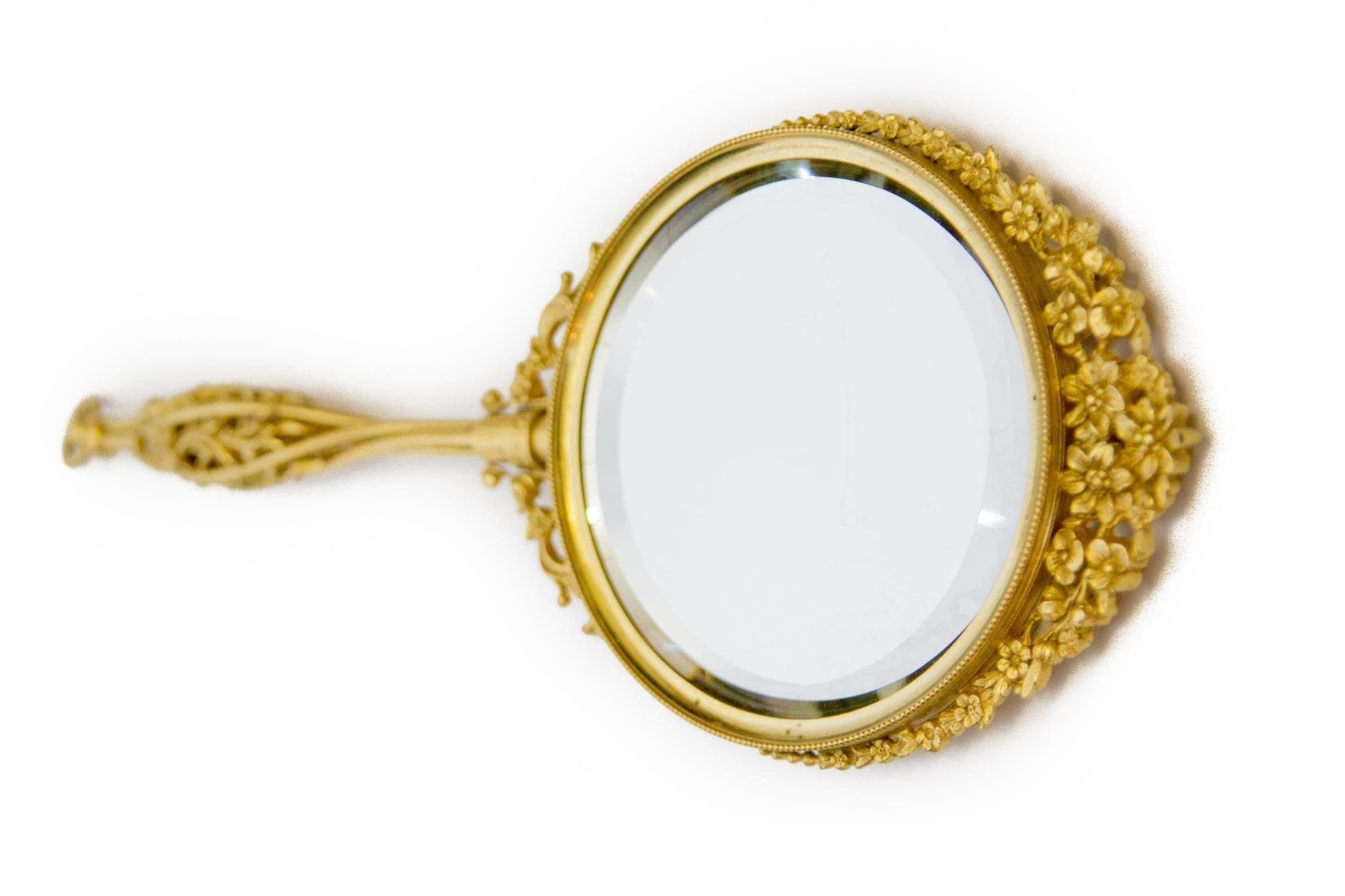 Gorgeous Victorian style brass filigree hand mirror with floral decorations and round beveled mirror. France, 1920s.
The reverse side of mirror can be opened, and it is possible to replace another picture or photo.
In excellent