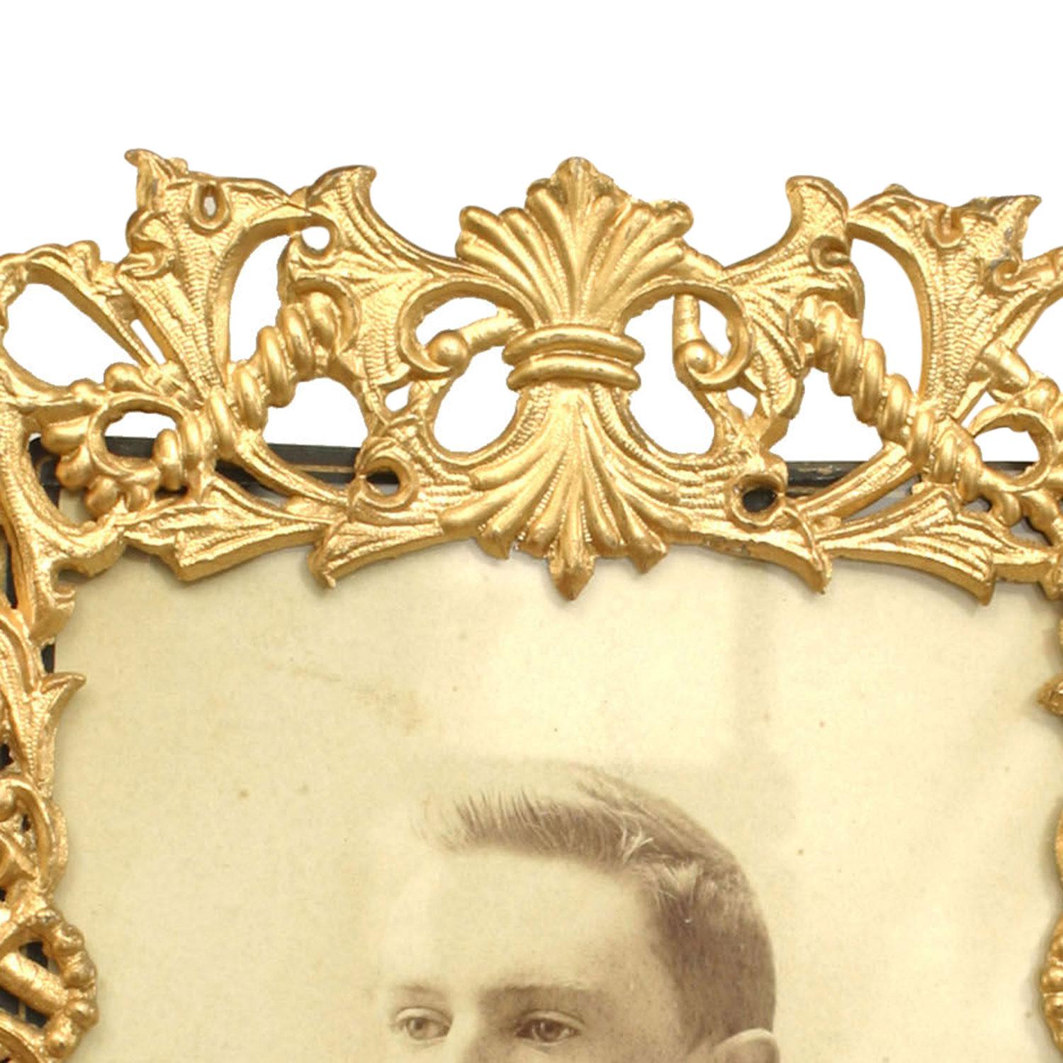 Cadre de chevalet rectangulaire en métal doré de style victorien français, avec un cadre floral filigrané et un cadre à volutes avec des coins à motifs de coquillages.