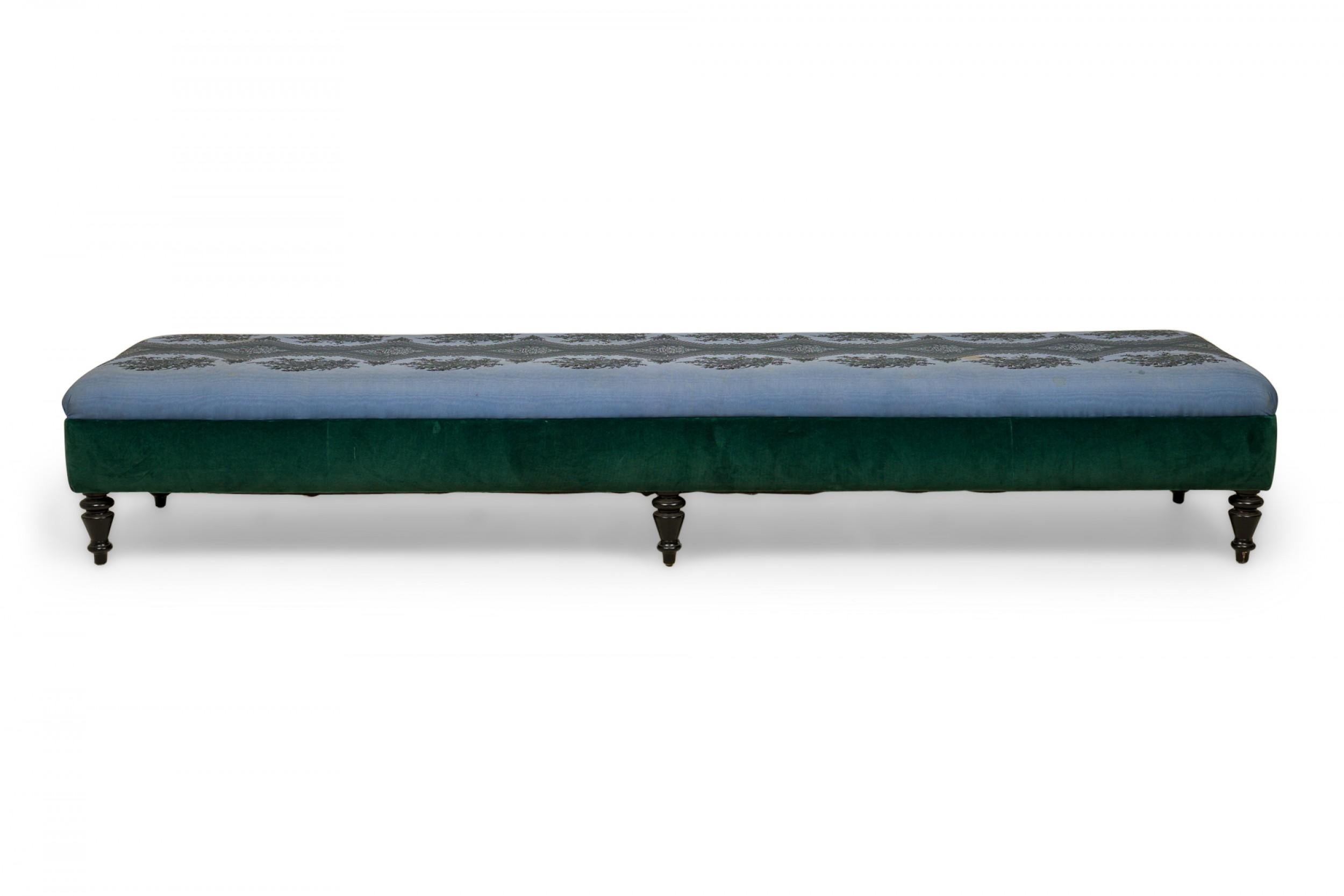 French Victorian-style long bench with a blue and green floral patterned upholstered seat with green border, resting on six black painted turned short legs.