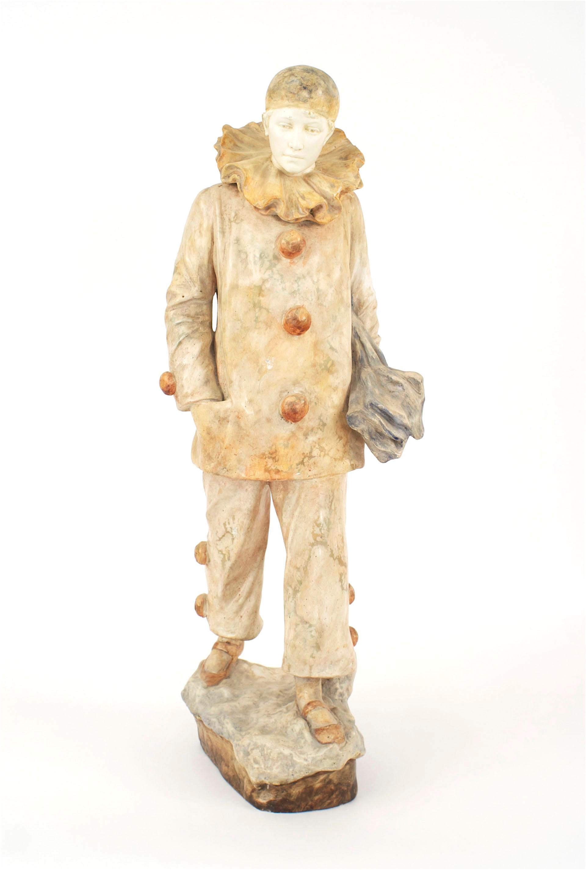 Figurine française victorienne en terre cuite d'un arlequin tenant un parapluie, au visage blanc et portant une casquette et un costume de clown avec de gros boutons (signé : HANISOFF, avec marquage supplémentaire)
