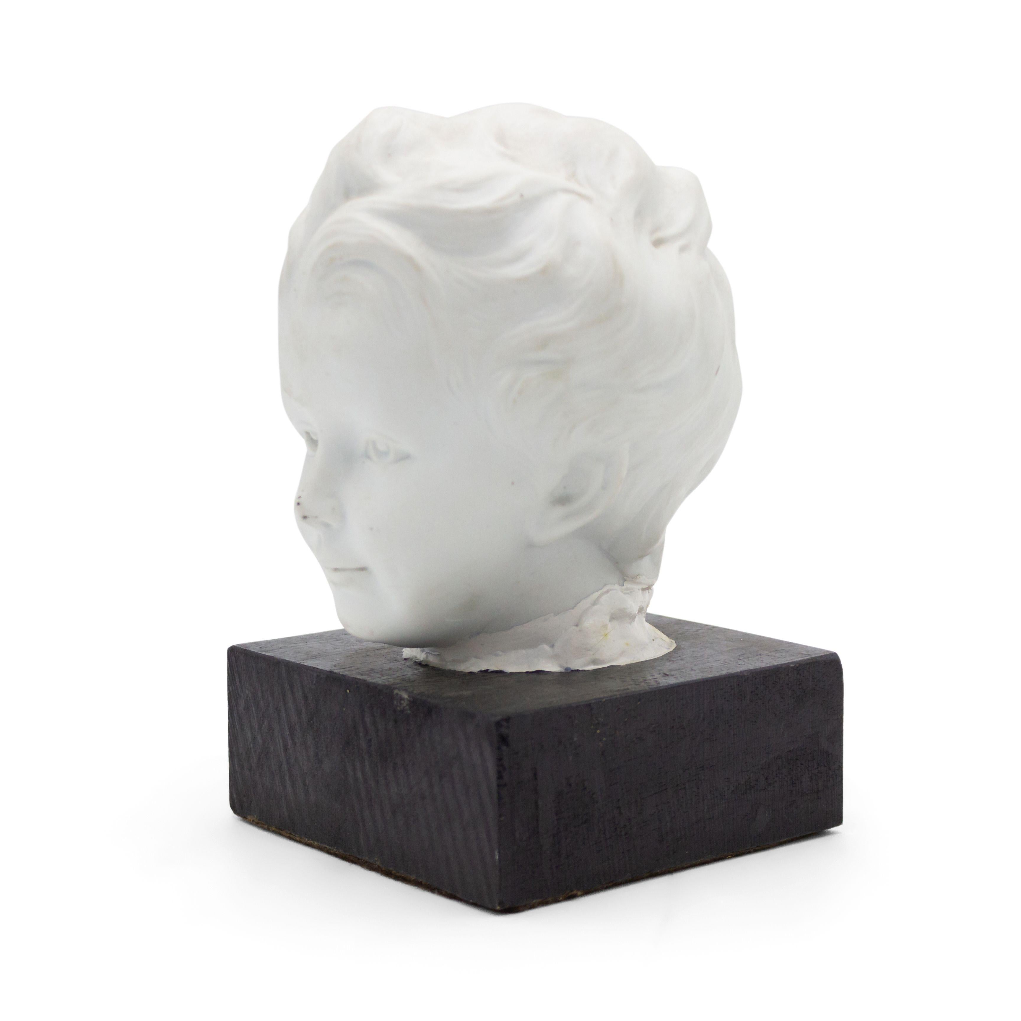 French Victorian style (20th Cent) white parium head of a young boy mounted on an ebonized square base (as is).
 