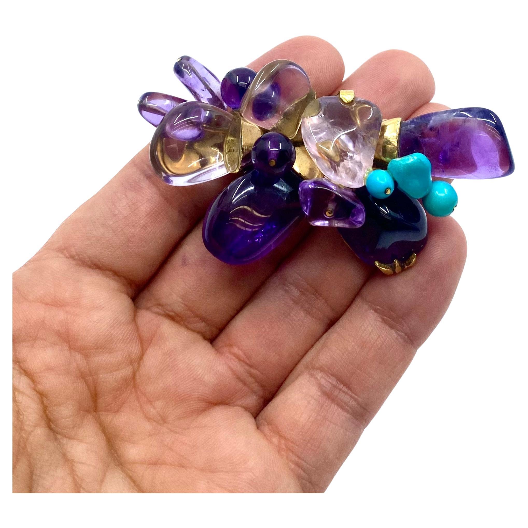 A gorgeous French brooch made of 18k gold, features amethyst and turquoise.  Designed as an abstract flower, the brooch has “petals” created from the freeform cabochon cut amethysts. Using various setting allowed placing the gems in different