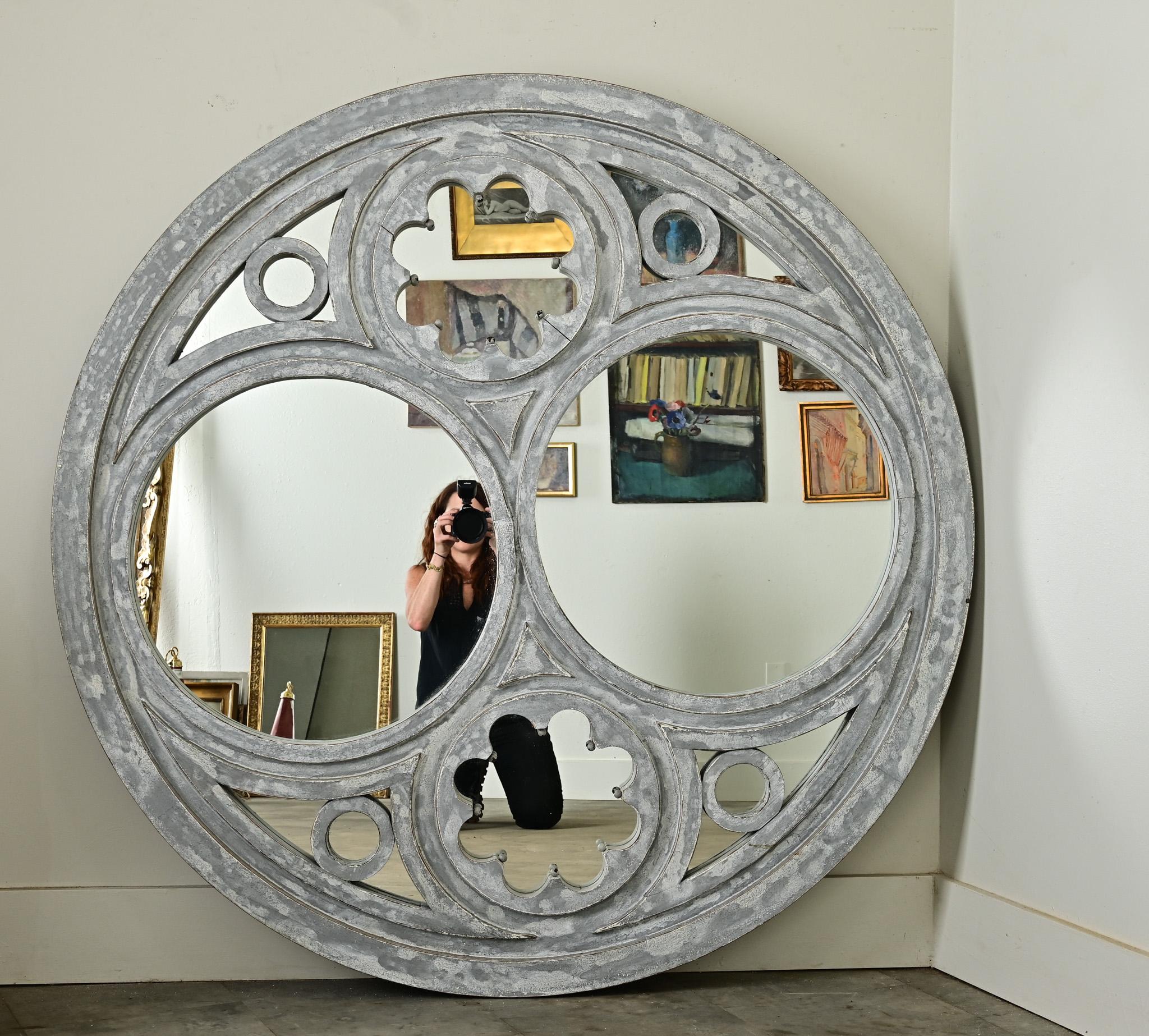 Ce superbe miroir rond français du 20e siècle permet d'évoquer l'émerveillement et la lumière d'une fenêtre de cathédrale. À l'intérieur de la forme circulaire se trouvent plusieurs ouvertures plus petites, parfaitement équilibrées par paires pour