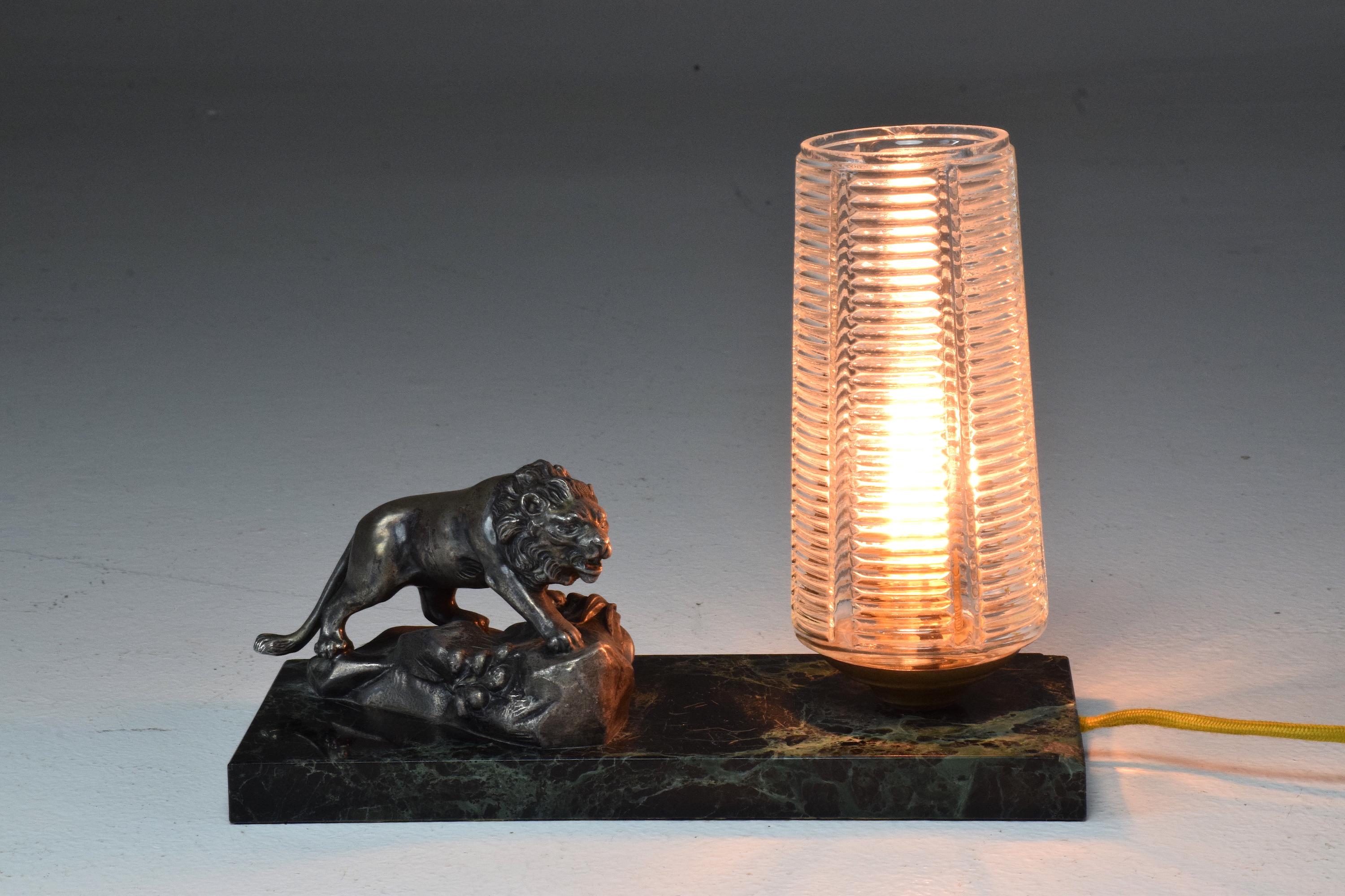 A 20th century French vintage pure Art Deco table lamp or bedside lamp designed with a green marble rectangular base, a textured glass removable shade and a heavy bronze lion figurine. 

Rewired and tested.