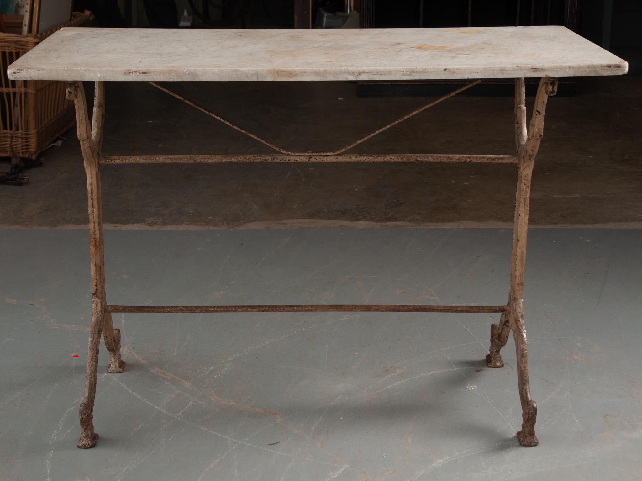 This amazing marble top garden table was made in France. The white marble top is in antique condition, with gray veins and softened corners. The cast iron base is classically styled, with fashioned upright supports, linked by two iron stretcher