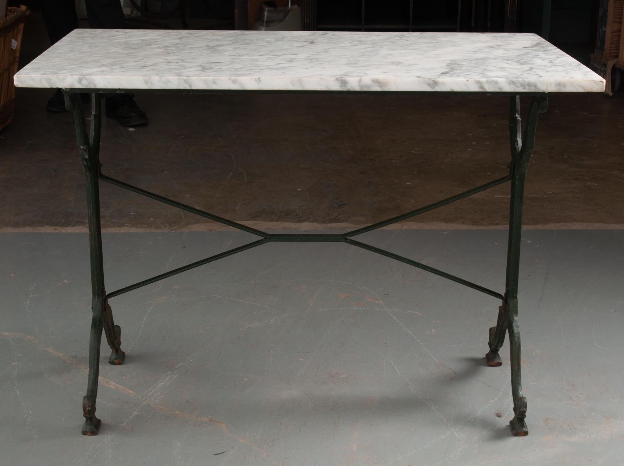 This amazing marble top garden table was made in France. The white marble top is in great condition, with gray veins and softened corners. The cast iron base is classically styled, with fashioned upright supports, linked by two iron stretcher
