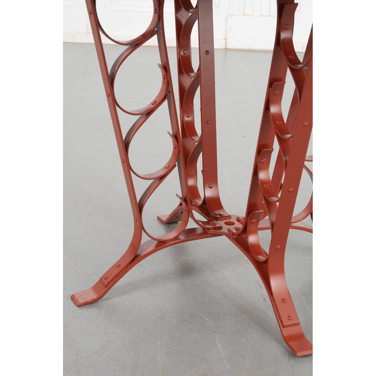 This charming vintage garden table comes from France. Made of metal it’s been sandblasted and powder-coated red for protection against the elements. The top is smooth with a hole for an umbrella measuring 1-?” in diameter. The legs have great