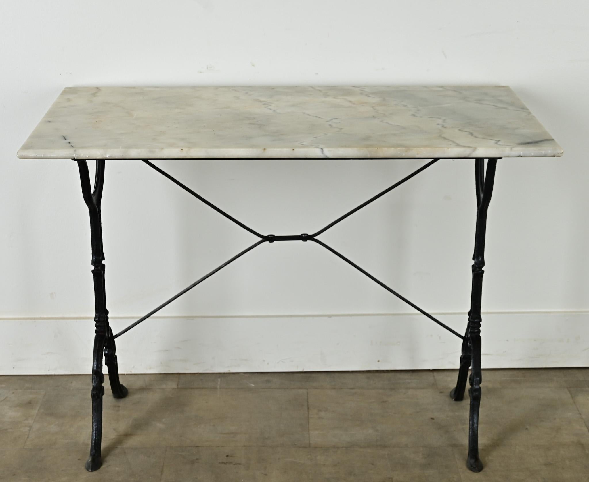 Beautiful French bistro table with white marble top on black, cast iron base. The natural stone has a smooth, honed finish and rounded edge for comfort. Yellowing of the marble is consistent with age and type of use. A lovely addition to a covered