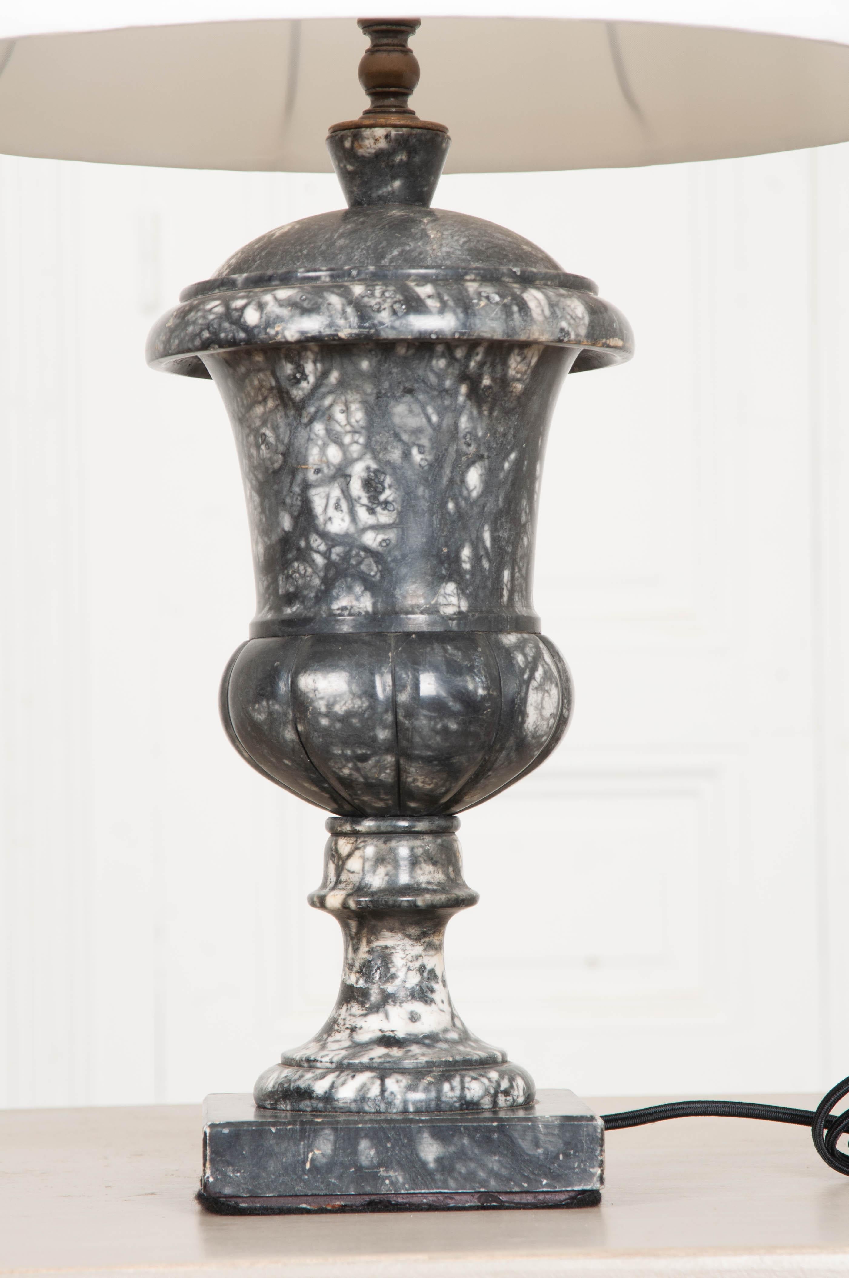 A classically styled urn, carved out of beautiful black and white marble makes a fine base for this refined vintage lamp from France. The lamp comes with a fine white linen shade. Cleaned and wired for US using UL listed components.