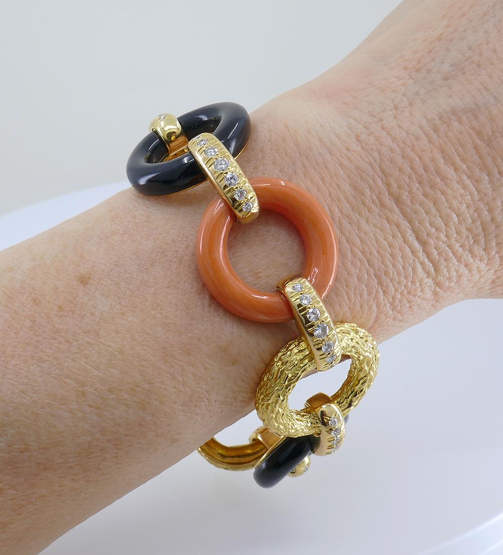 A beautiful vintage French bracelet, made of 18k yellow gold, featuring diamond, coral and black onyx.	
The vintage bracelet comprises seven round-shaped links connected by the horizontal loops. The loops are embellished with diamonds. The circles