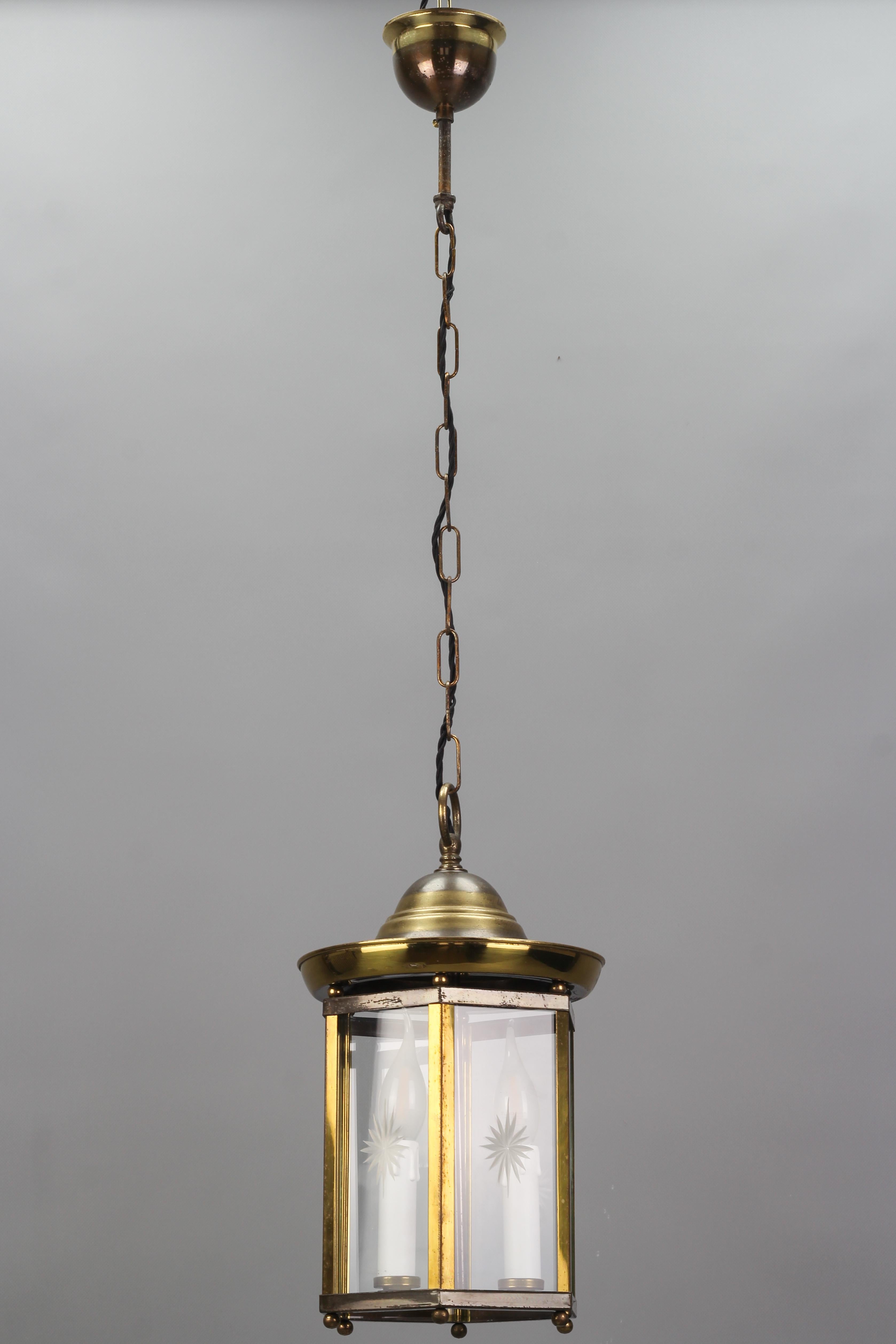 French vintage brass and cut clear glass hexagonal hanging lantern from circa the 1950s.
This adorable pendant lantern features a hexagonal brass and metal frame with a round-shaped top and canopy. Six clear glass panels each with the cut decor of