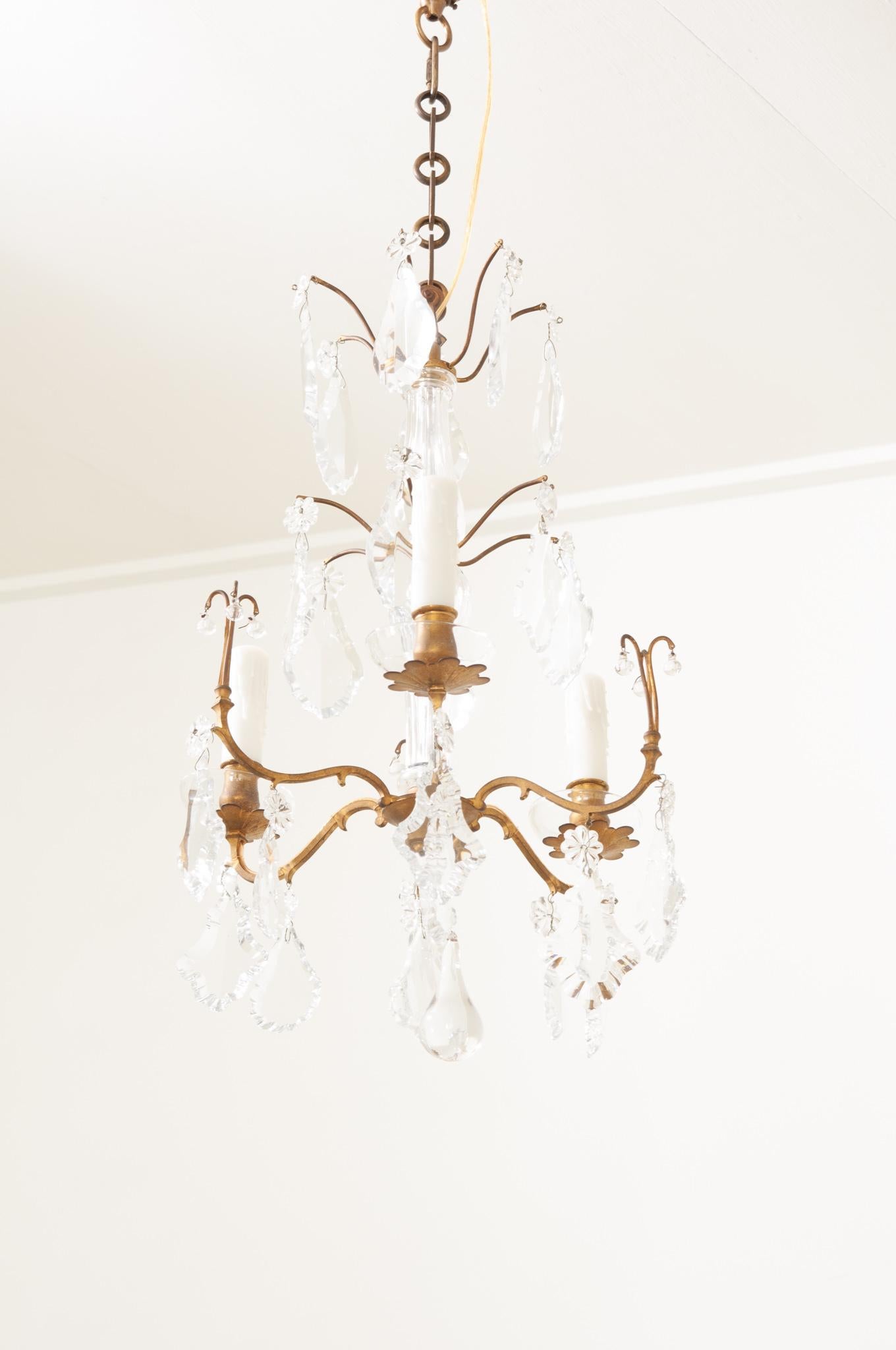 A petite brass framed 3 light chandelier with crystals that sparkle in the light. Recently rewired for the US with UL certified parts. Be sure to scroll through the detailed images.