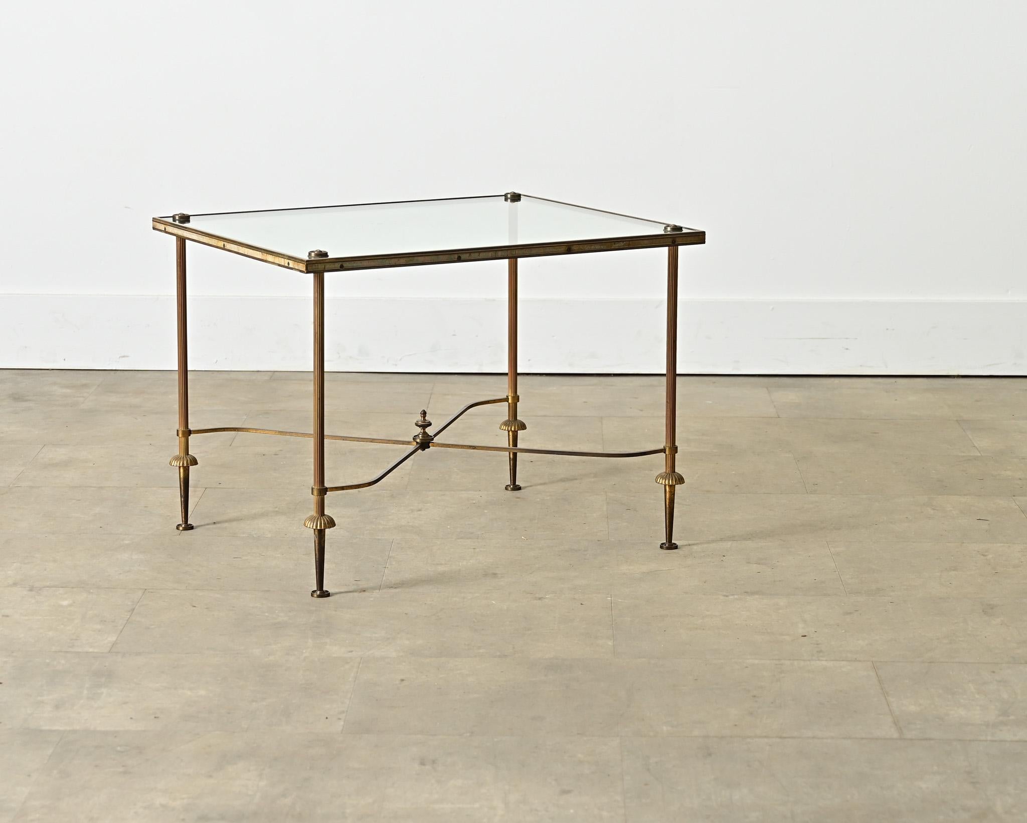 A vintage, midcentury French brass and glass coffee/cocktail table in the style of legendary firm Maison Jansen that will impart cosmopolitan glamor to any interior. Reflecting the typical aesthetic codes of Hollywood Regency taste, the brass frame