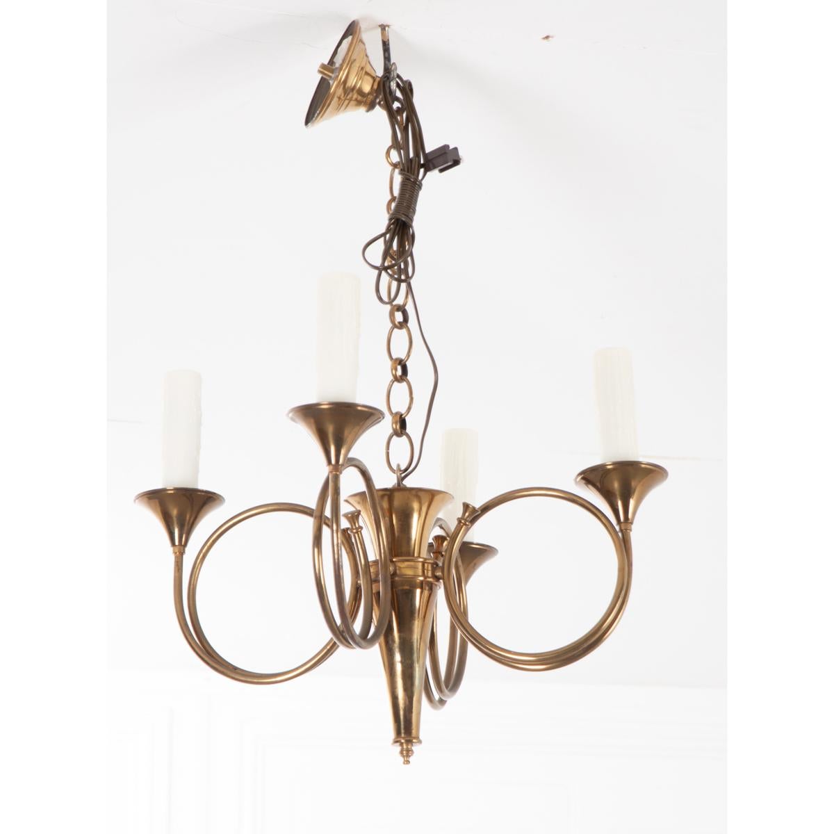 This is a fabulous brass finished, four-light chandelier. It mounts directly to the ceiling and extends down with a brass chain holding four horn-like candelabras. The faux candle fixtures are larger than normal and are quite nice. This simple yet