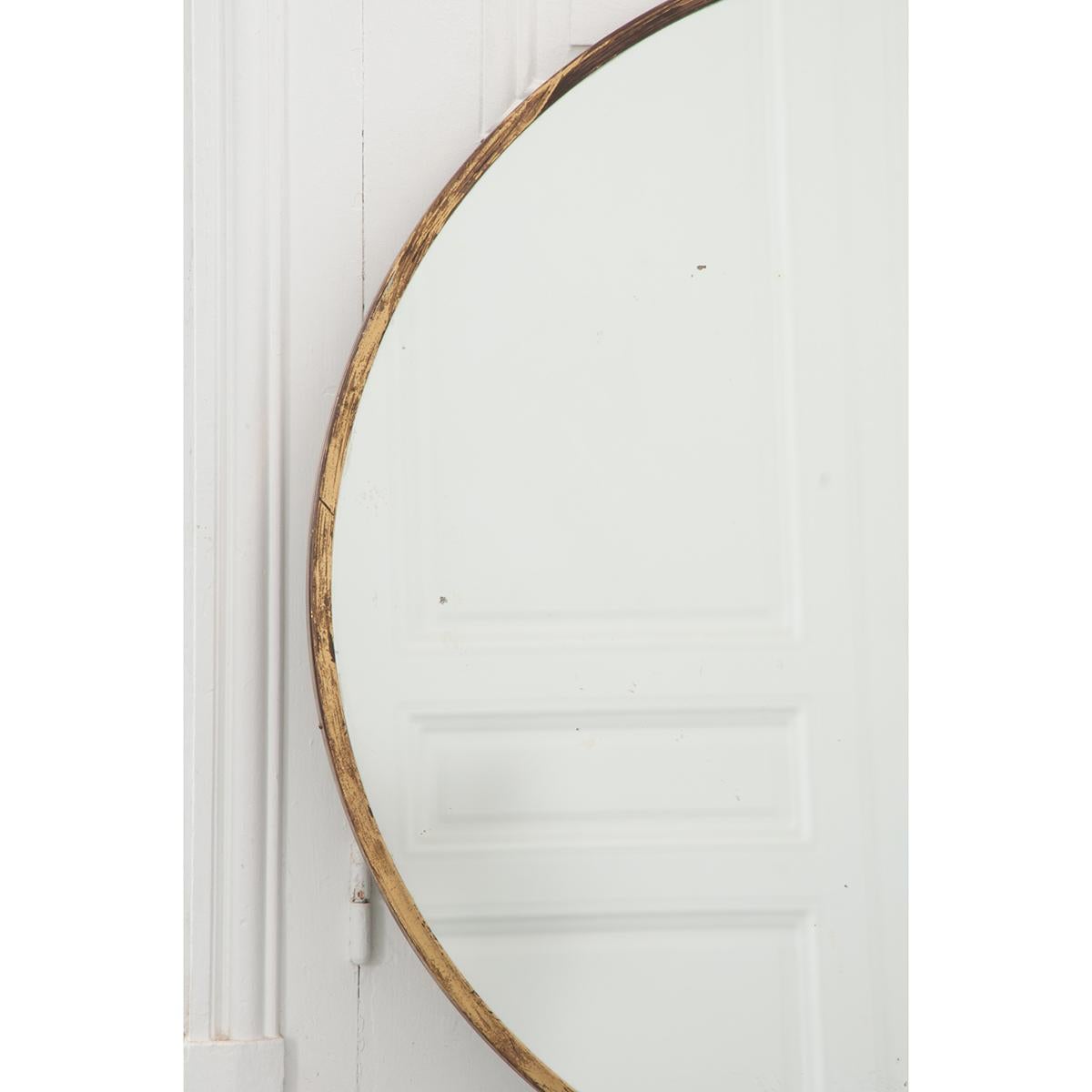 This French vintage brass edged round mirror is circa 1960. It has its original mirror plate which shows aging. The brass edge shows scratches and signs of aging also. Please be sure to view the detailed images.