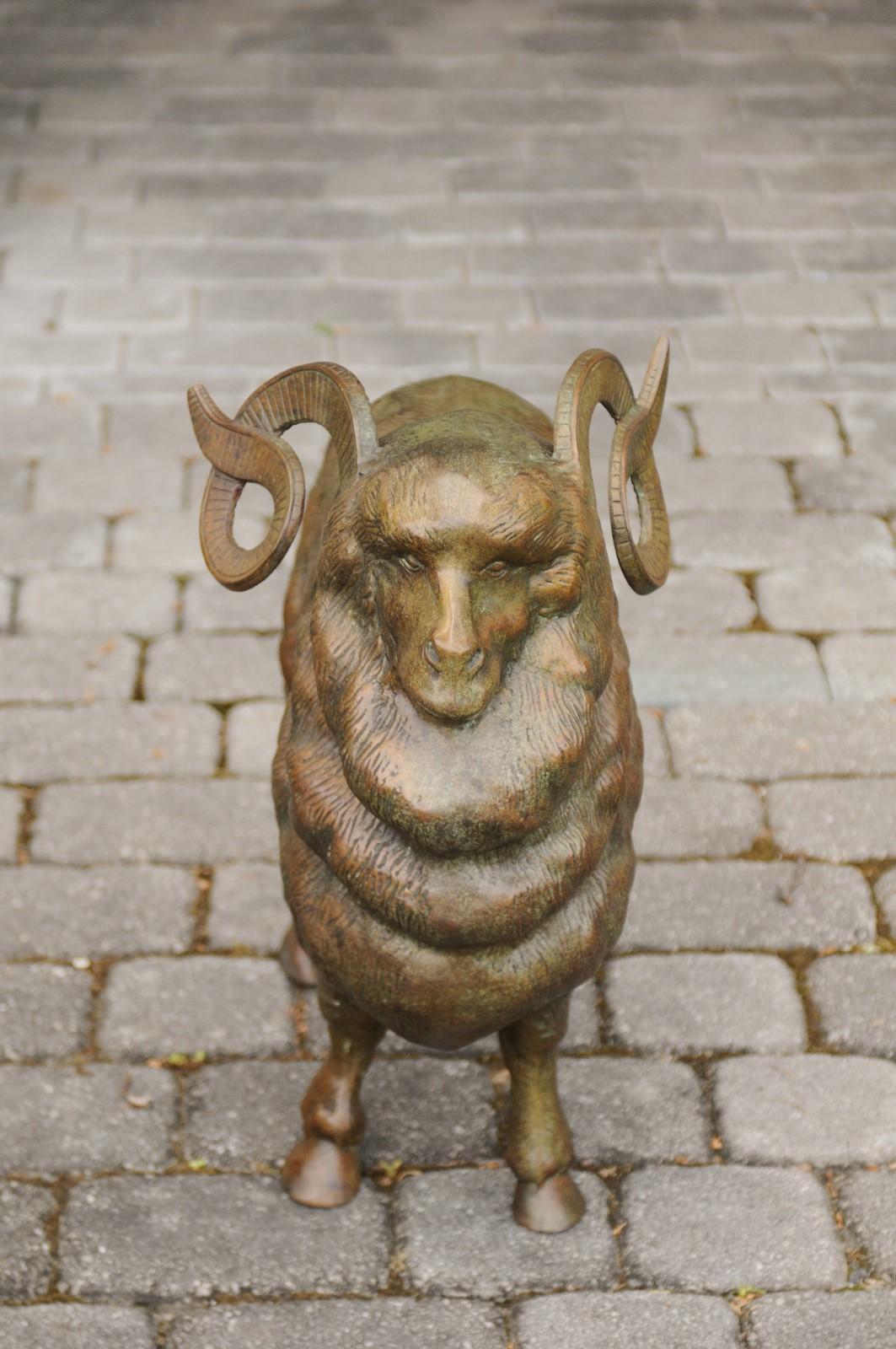 A vintage French bronze ram sculpture from the mid-20th century with large horns. Born in France during the midcentury period, this striking bronze sculpture depicts a ram, standing proudly on his four paws. His air of majesty is perfectly accented