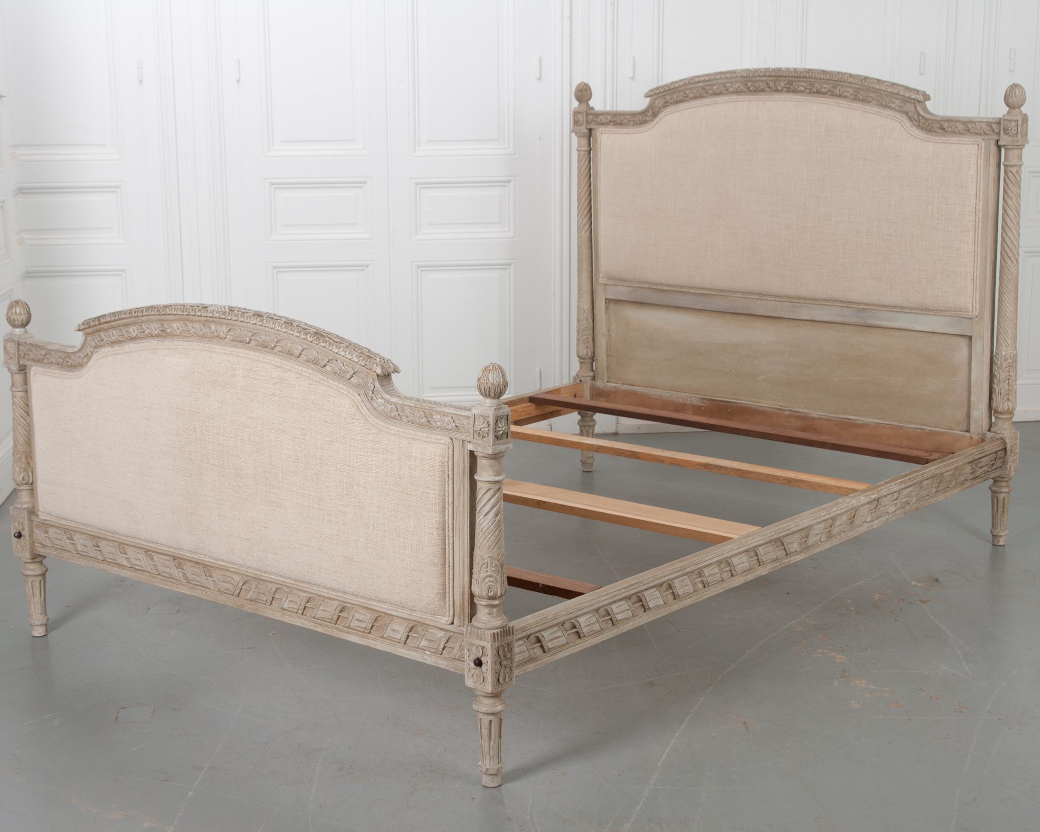 Painted a creamy gray color, this vintage bed is made in the French Louis XVI style and features many of the stylistic details of that period. Pomegranate finials cap the turned and twisted columns found at the bed’s four corners. These columns