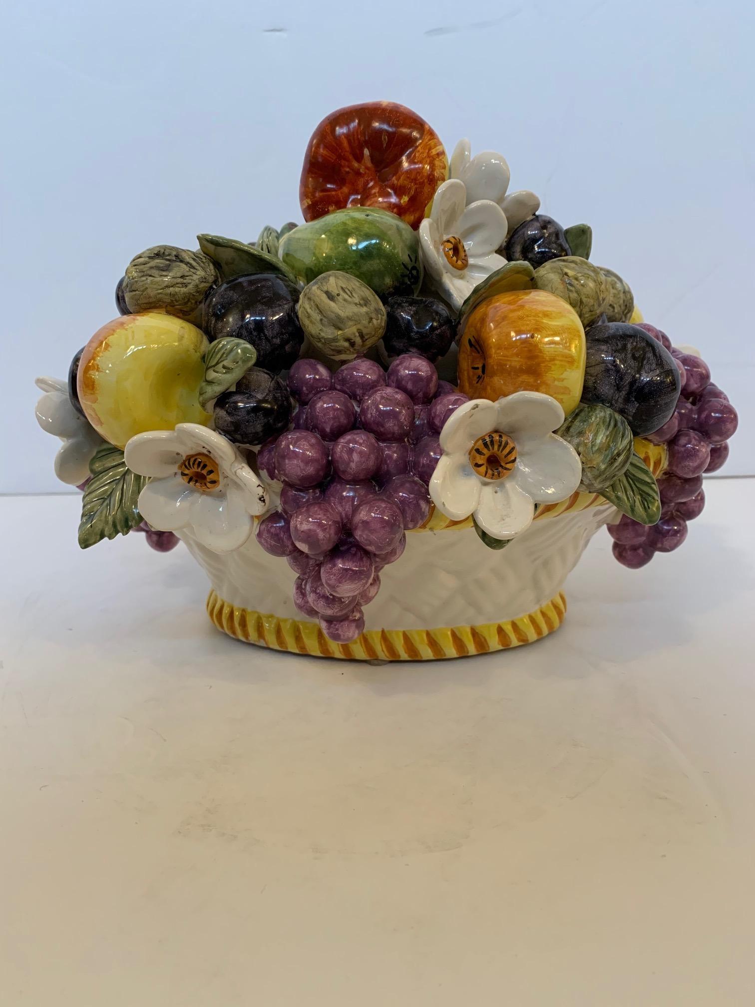 A beautiful Majolica style ceramic bowl of fruit and flowers from France having incredible coloration and detail. Says fait main and made in France on the bottom.
