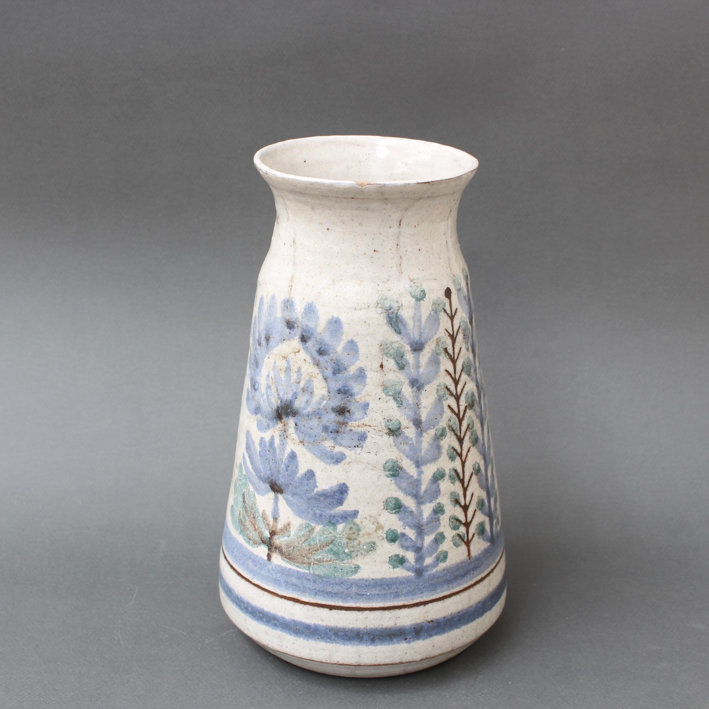 A French Vintage ceramic vase by Le Mûrier (circa 1960s). This sizeable yet elegant flower vase is a delightful work of art in the trademark style of Gustave Reynaud and Le Mûrier. On the rustic exterior you will find charming flowers with blue