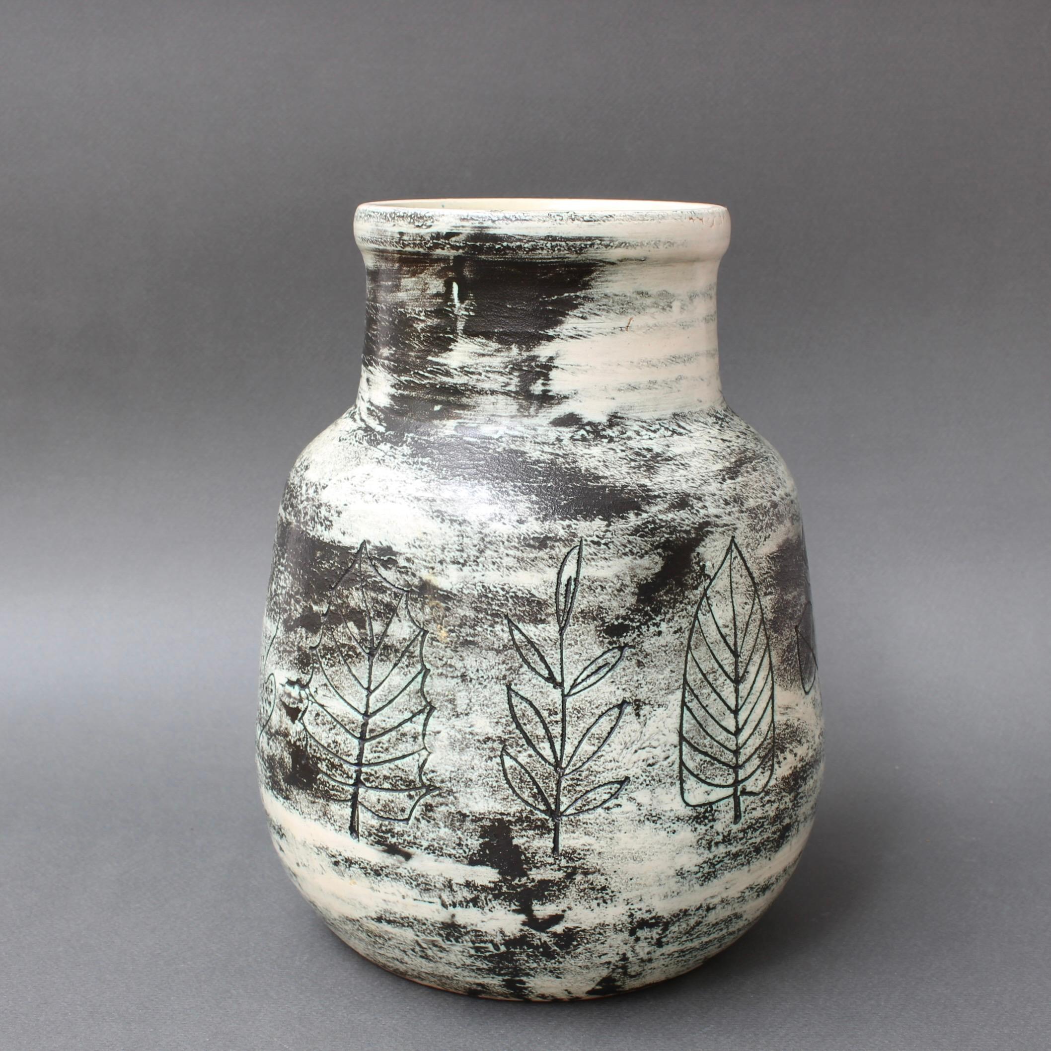 French mid-century ceramic vase by Jacques Blin (circa 1950s). A serious yet delightful piece created using Blin's trademark misty glaze with lovely decorations of plant life such as leaves, branches and stems. The spherical central portion houses