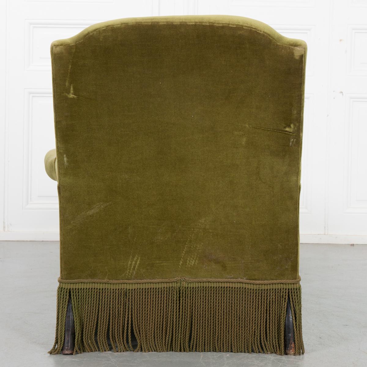 This green fringed chaise lounger is absolutely stunning. The color and texture of the worn upholstery add a touch of vintage sophistication to any living space. Fringe along the whole of the bottom hides the turned wooden feet and give it a look of