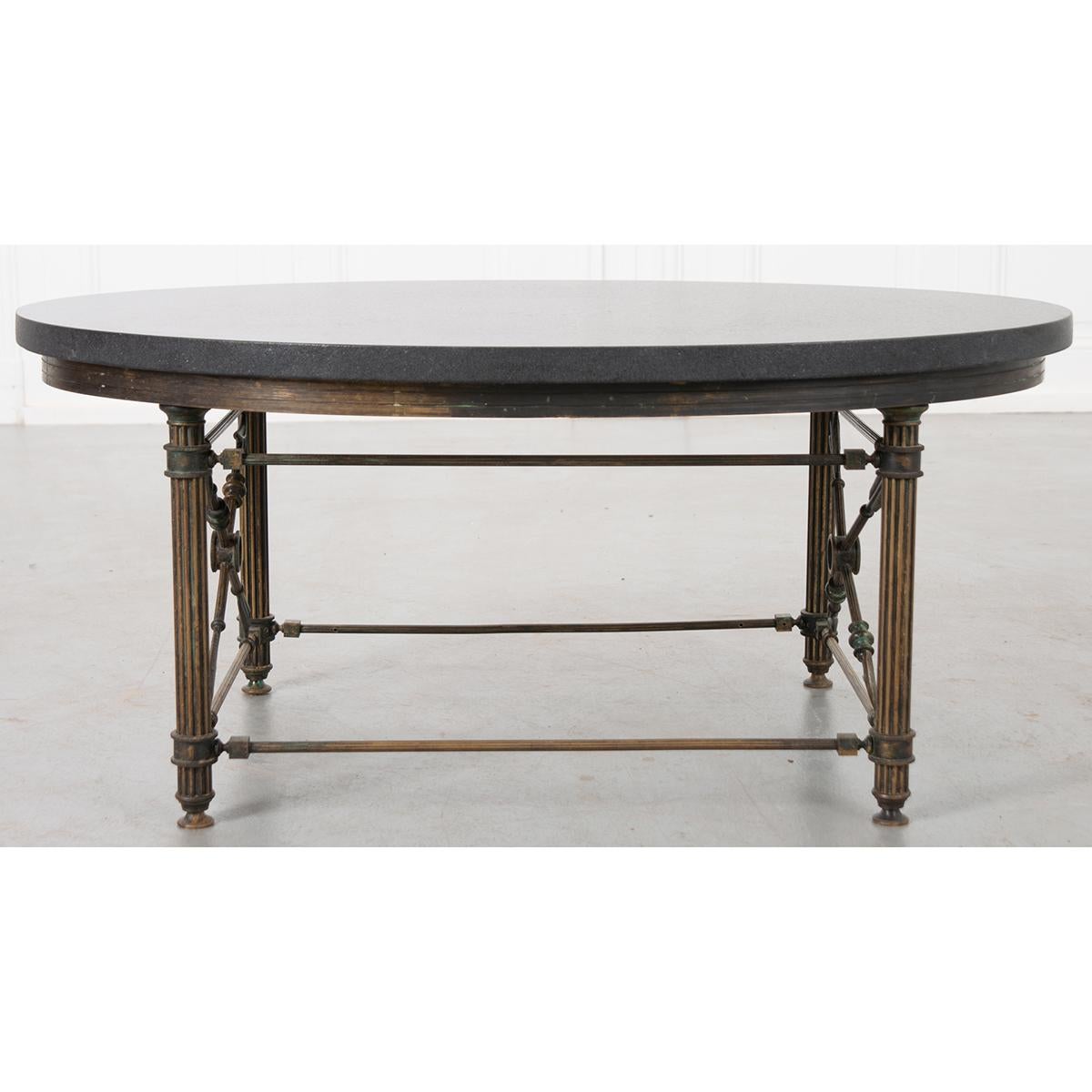 This is a fantastic French vintage brass coffee table base. Made of brass, it has crossed arrows on both ends. It is topped with a new black marble top with a leather finish. Would be very nice in a small space.