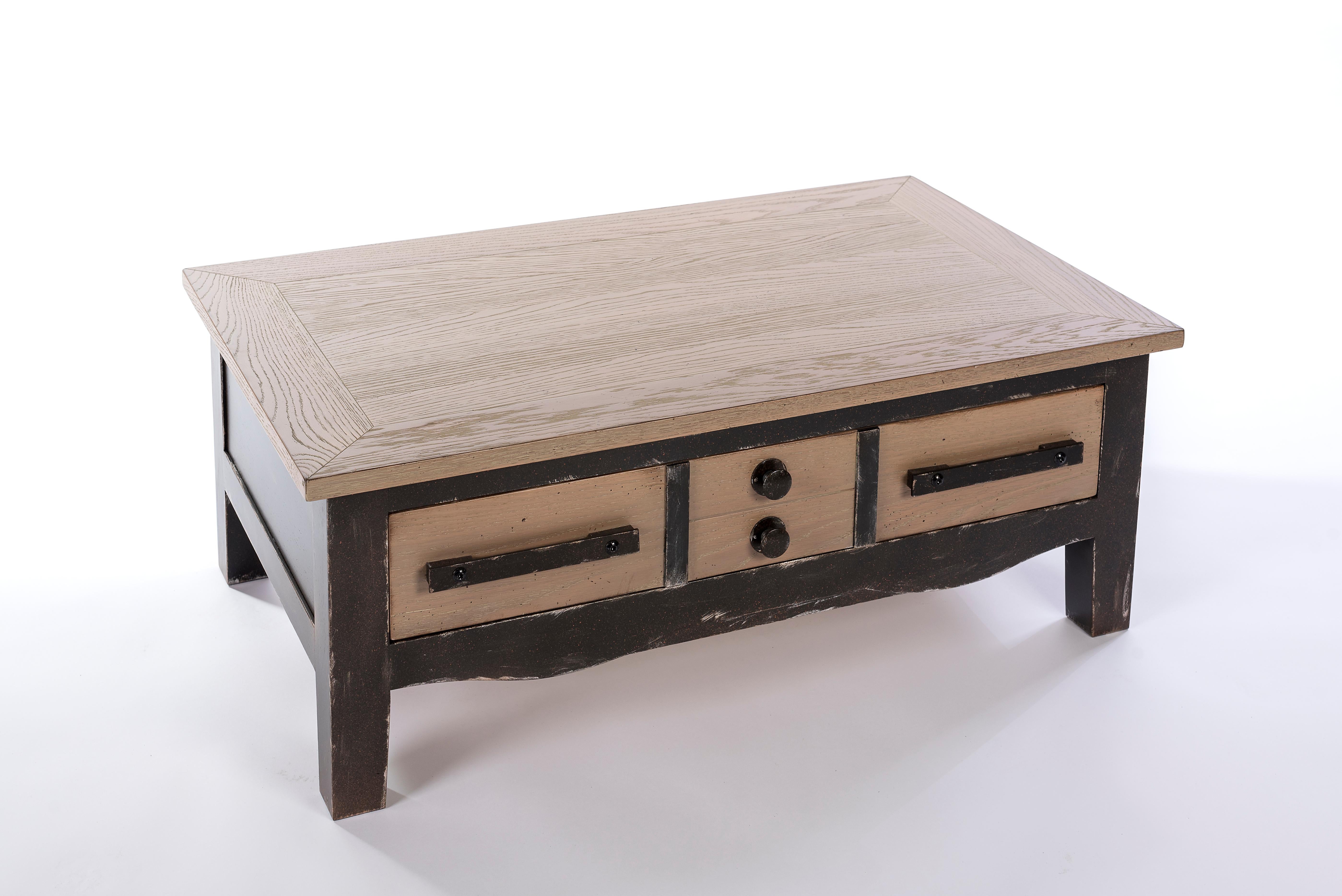 This coffee table from a French Countryside style is reinvented with dark colors and a unique finishing as an imitation gun metal to present an Industrial Style. 

The table features one large back and forth drawer in oak. 

The sourcing of the