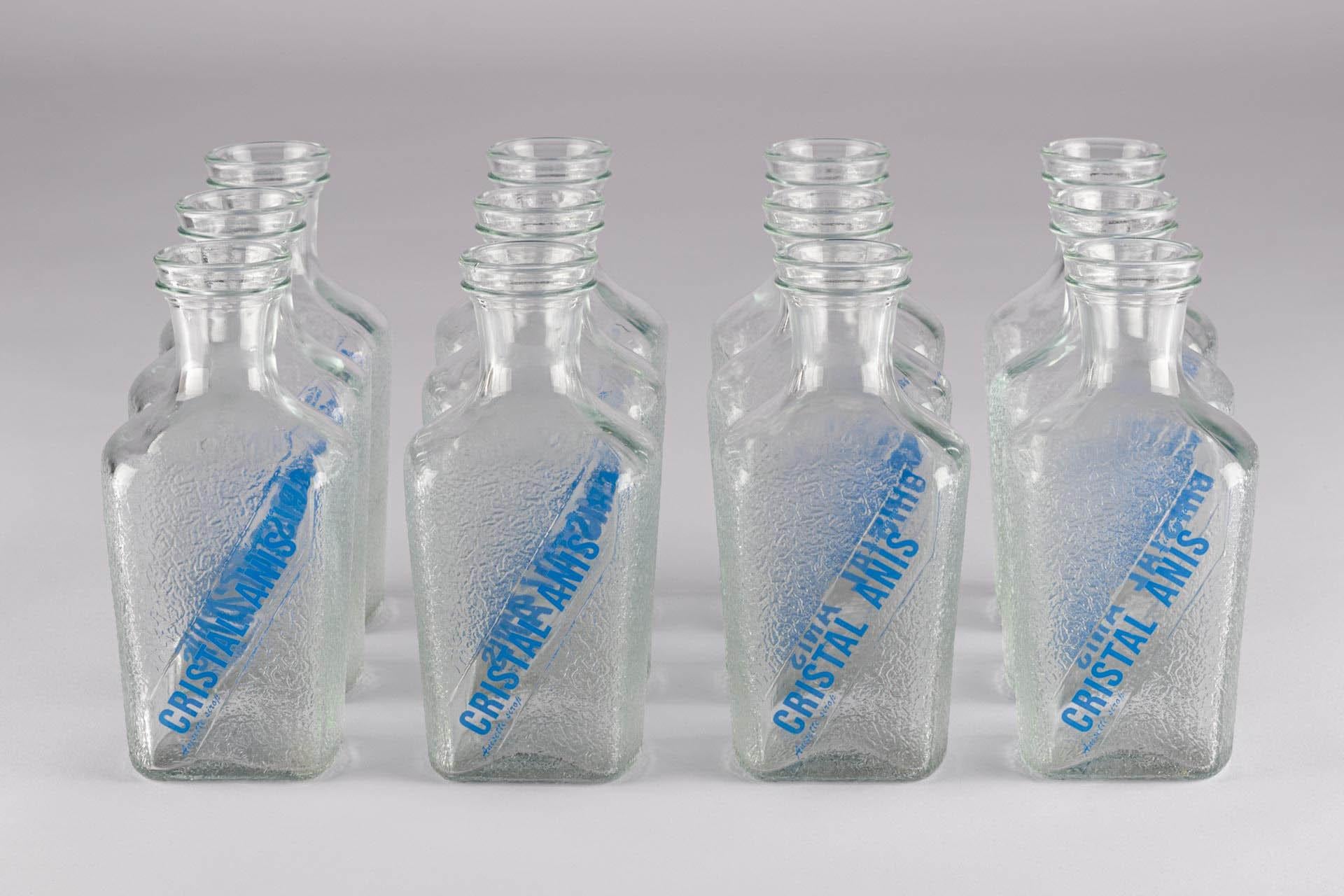 French Collection 12 Cristal Anis Clear Water Drink Bottles Brocche d'acqua vintage 

Francia 
Vetro
Metà del XX secolo 

Dimensioni: H. H. x L. x P. 20cm x 7,5cm x 6,5cm

Questa pregiata collezione è composta da 12 bottiglie etichettate con il logo