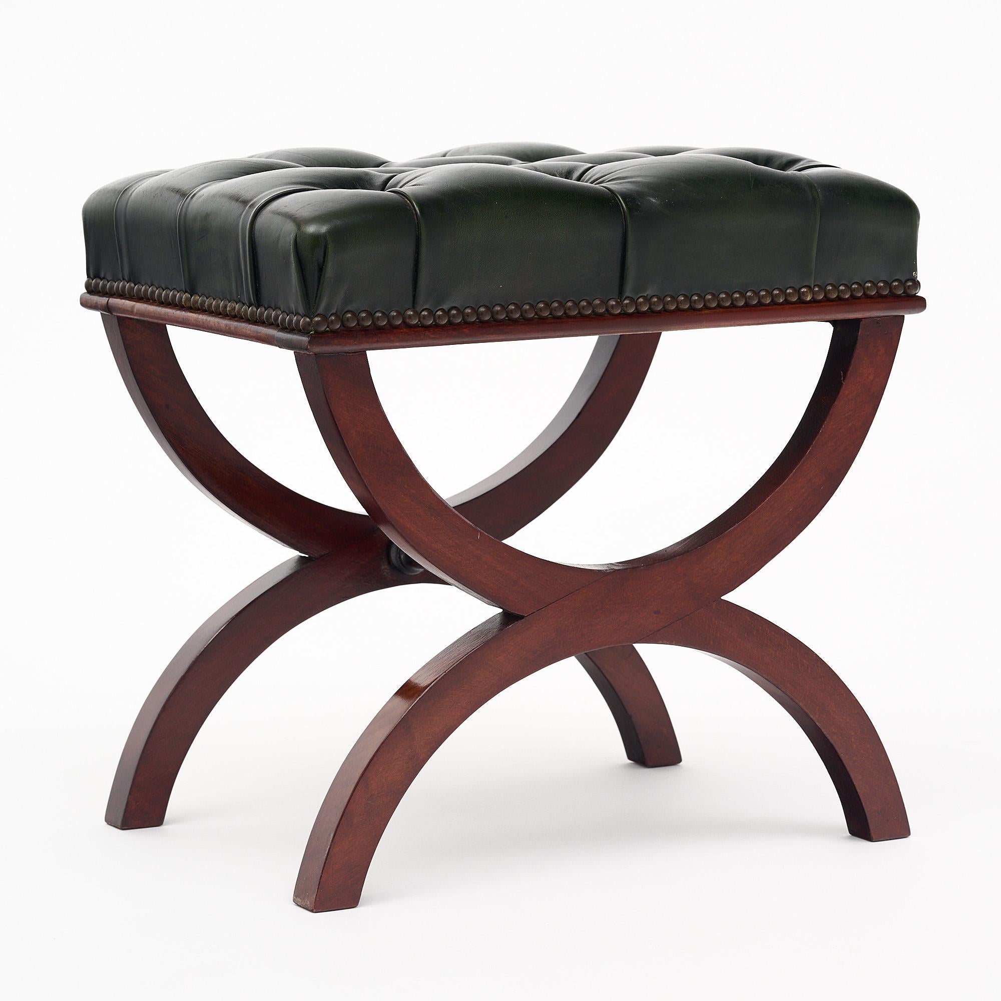 Curule stool from France made with a hand-carved solid mahogany base and original tufted leather upholstery. The upholstery features the original brass nailhead trim as well. We love the classical details of the piece and the quality craftsmanship.
