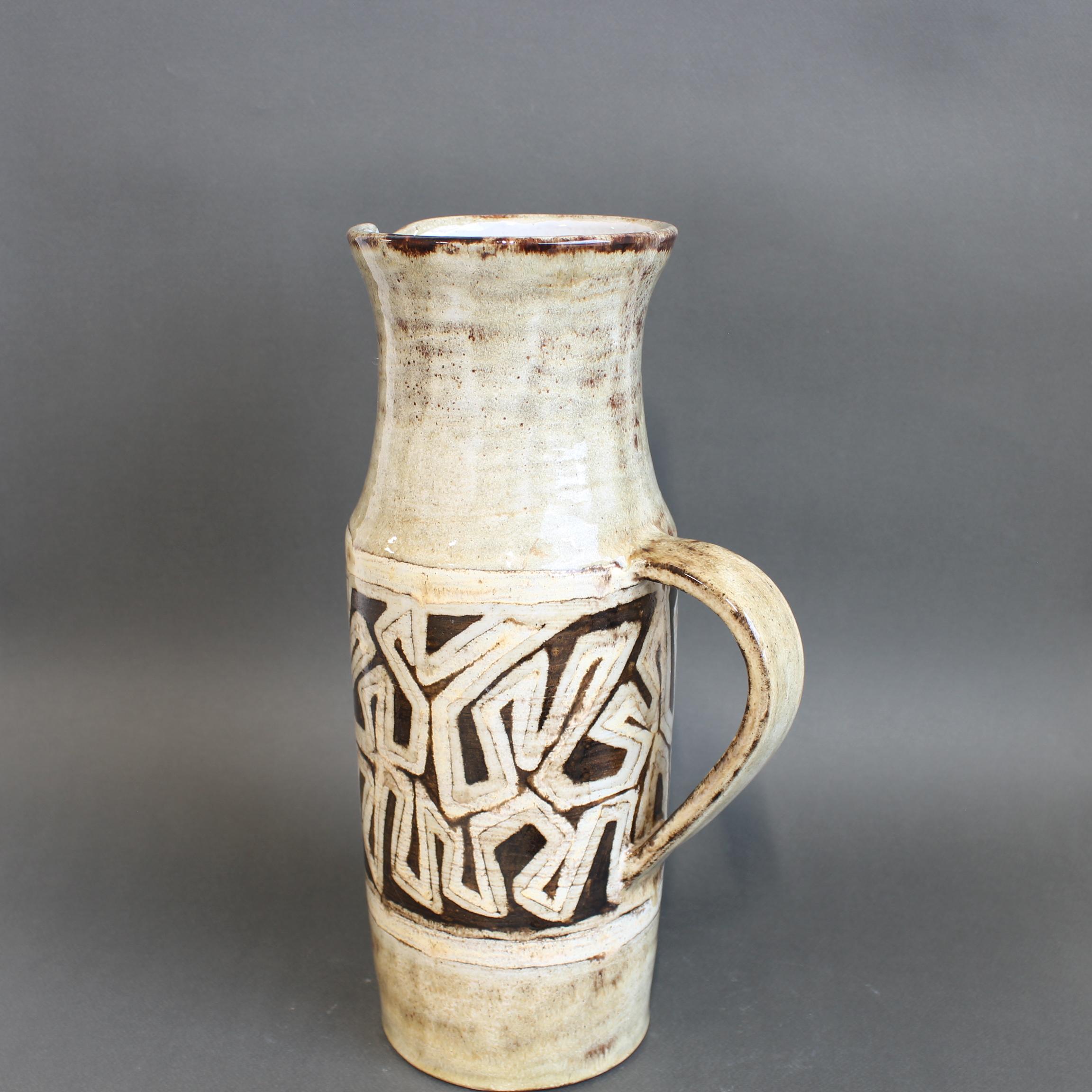 Dekorativer Keramikkrug von Robert Perot, dem Gründer der Töpferei Vieux Moulin (ca. 1960er Jahre), Vallauris, Frankreich. Charmantes Stück aus glasiertem Steingut mit abstraktem Motiv in der zentralen Zierleiste. Das Motiv erinnert an ein