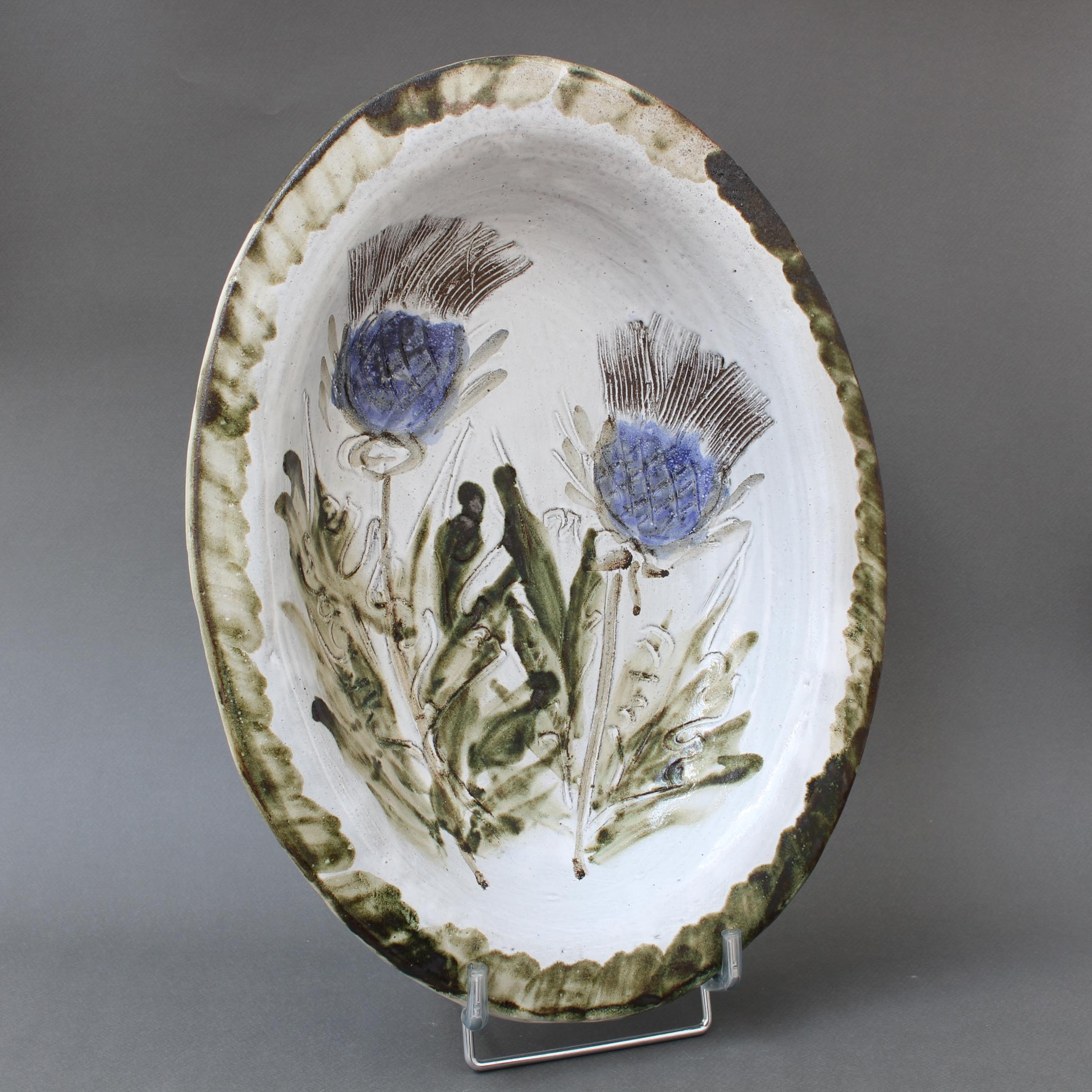 Large mid-century decorative platter (circa 1970s) by Albert Thiry. A creamy-white glaze with touches of blue-grey provides the background for a colourful thistle motif in the centre recess. The rim assumes the colour of the flowers' foliage, some