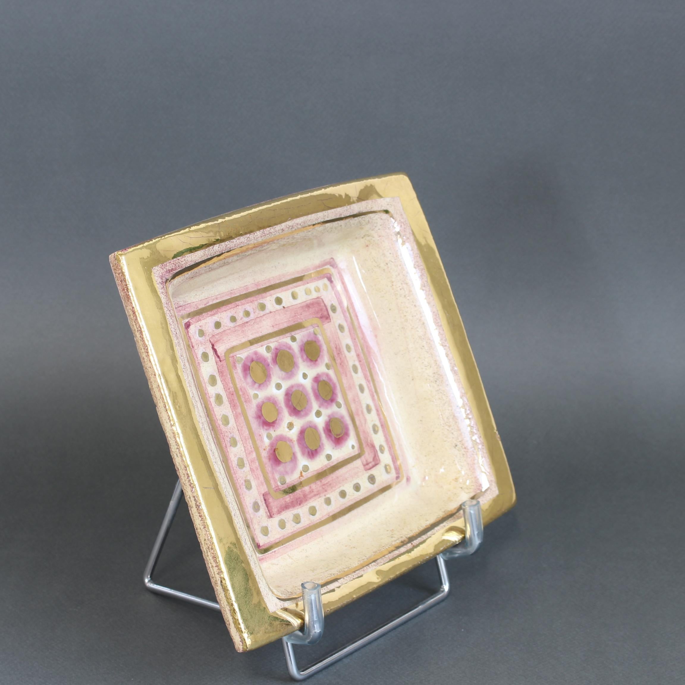 Vide-poche / plat décoratif par Georges Pelletier (circa 1970). Fabriquée à la main, la céramique aux reflets roses et à la craquelure dorée est une pièce étonnante. La base encastrée du plat présente un motif carré concentrique avec des bordures