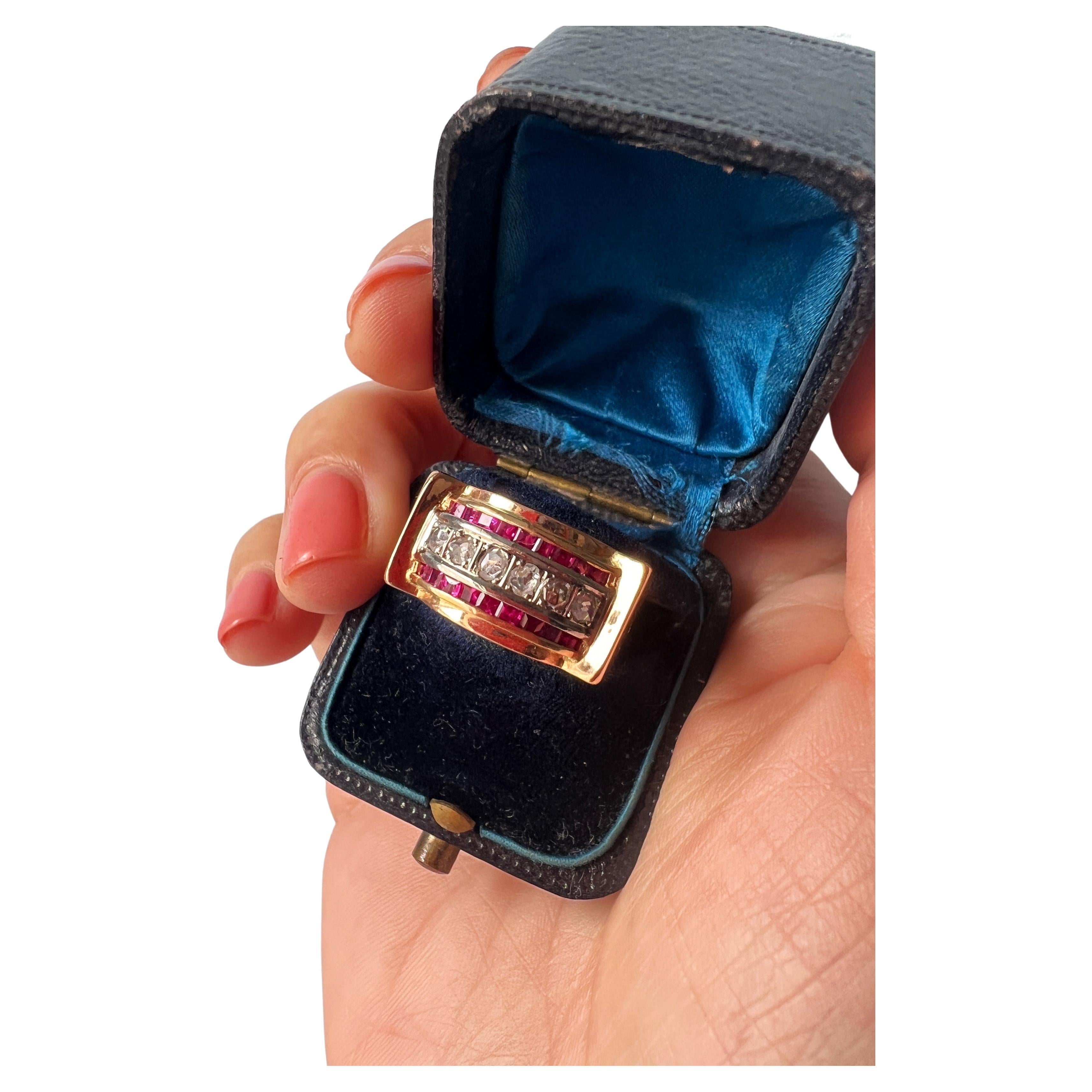 For sale a typical tank ring from the 1940s, marked by its massive use of 18K yellow gold, geometric motifs combined with a line of 6 rose cut diamonds closely set in the middle of two lines of purplish red rubies cut in baguettes.The quality of the