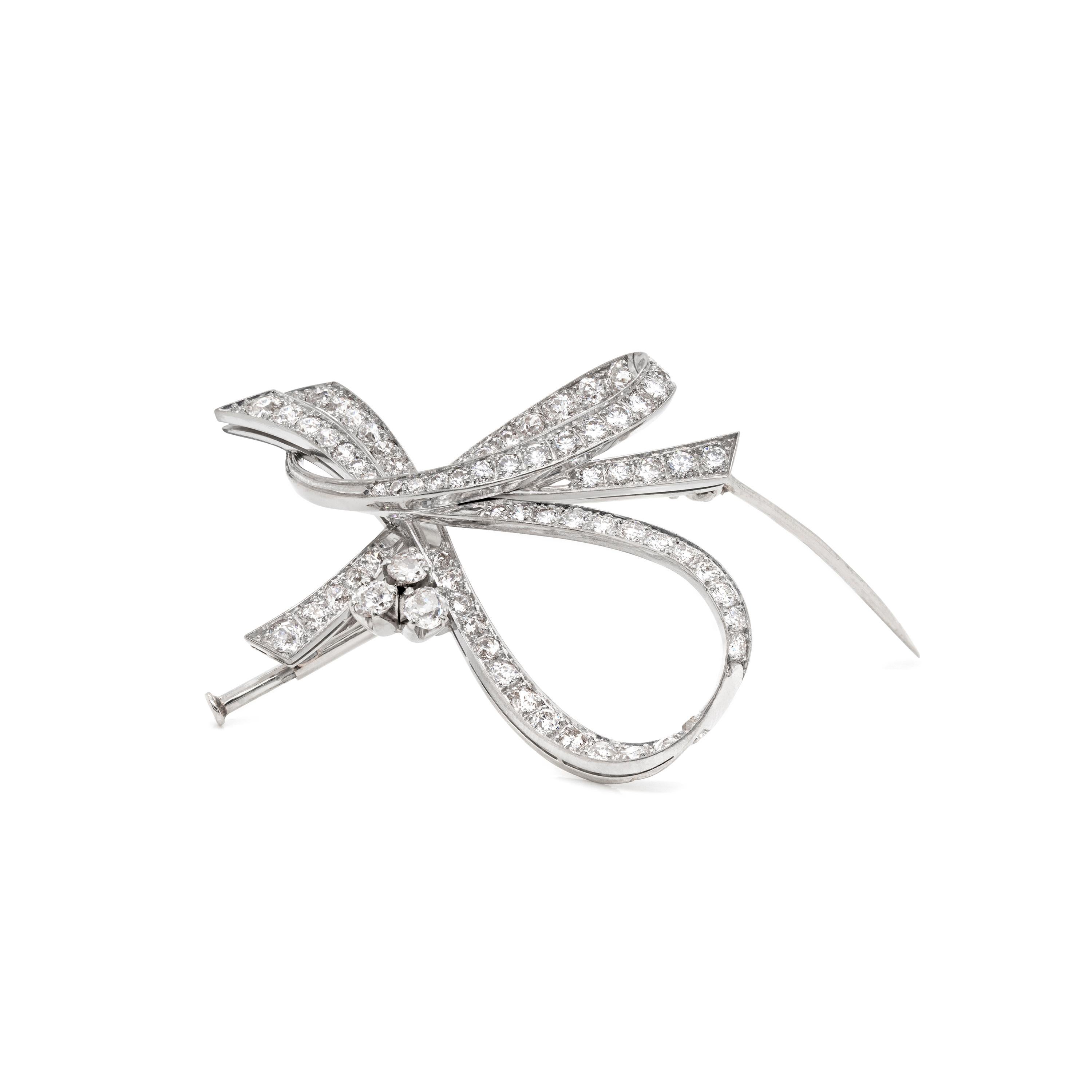 This gorgeous vintage brooch is beautifully pavé set with a mix of round brilliant cut diamonds and old cut diamonds, all mounted in platinum. The meeting point of the twisted ribbon is embellished by three claw set old cut diamonds placed on its