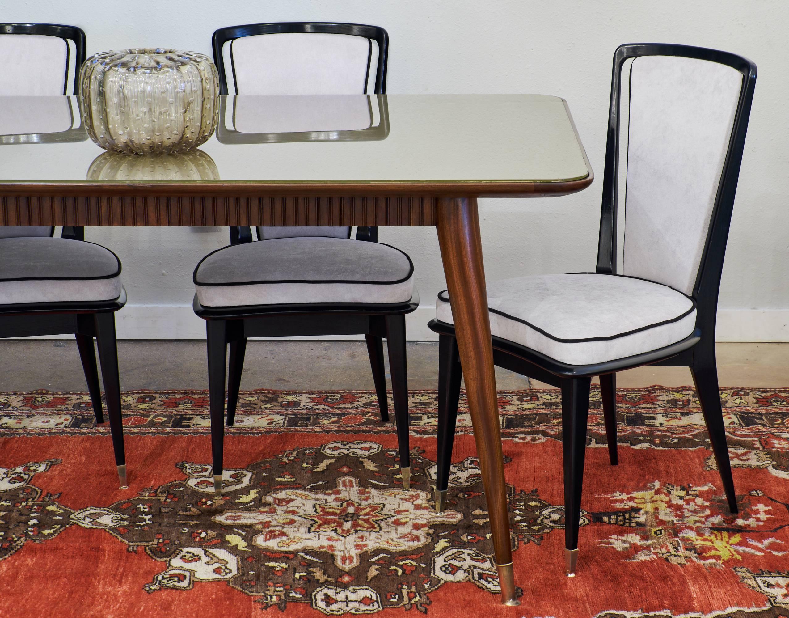 Set of six Mid-Century Modern dining chairs with ebonized and French polished cherrywood and brass feet. These sleek chairs feature curved seats, newly upholstered grey velvet and black velvet cording.