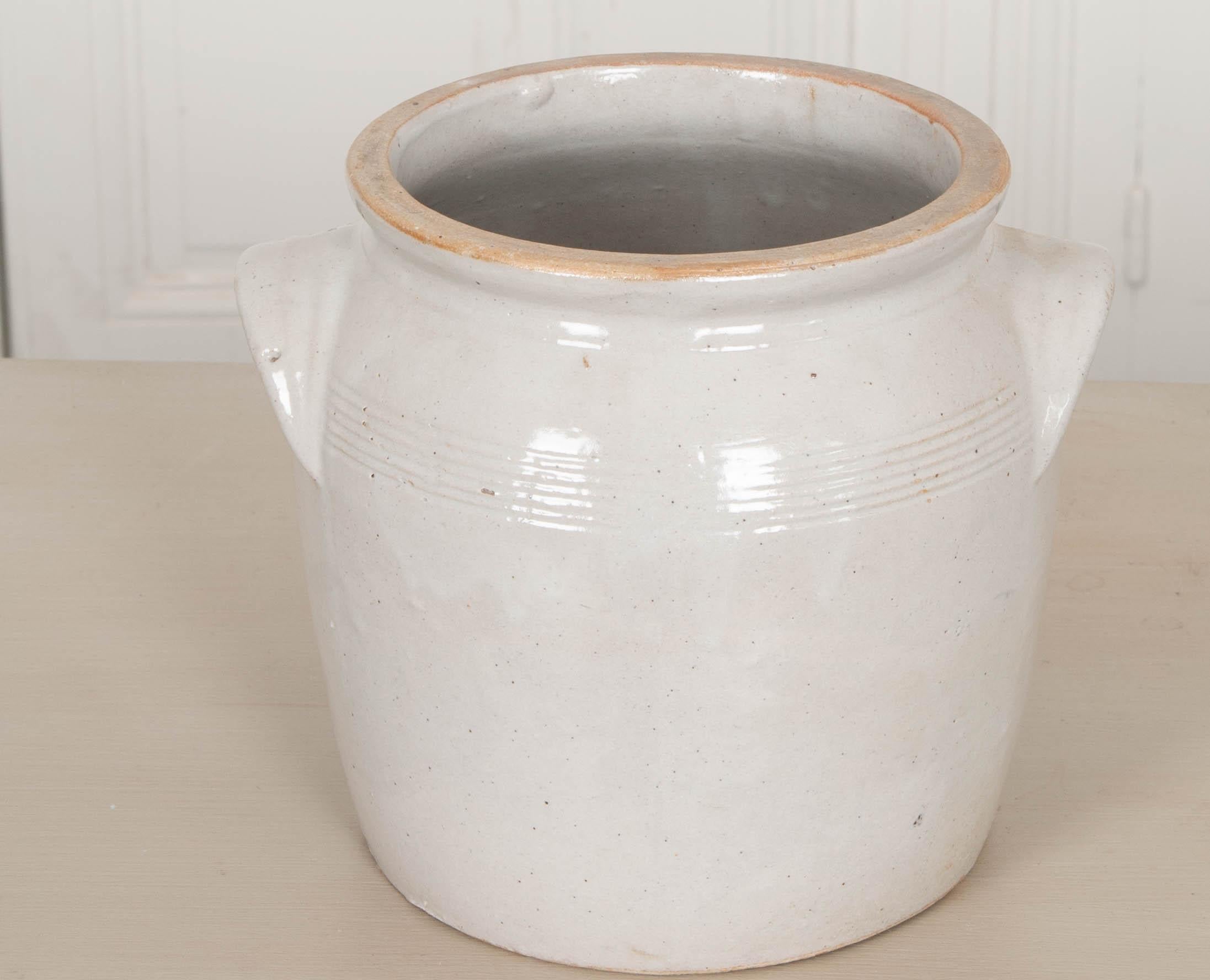 This vintage Provincial glazed earthenware crock is from France. Its cupped handles make lifting the pot a little easier, and the decorative banding found between them gives it a distinct style. Every ceramic pot will differ slightly, as they are