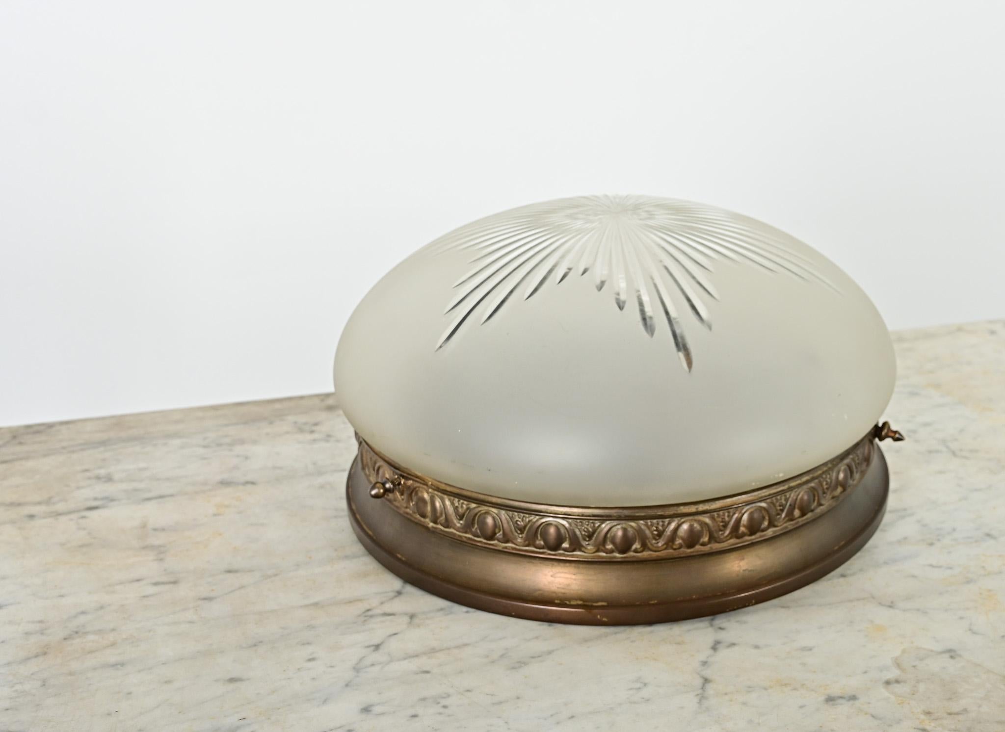 A lovely antique flushmount ceiling light, French circa 1930. The cast bronze ring is decorated with a band of egg & dart motif, which contrasts beautifully with the suspended bowl of frosted glass, cut-to-clear in a dazzling starburst pattern.