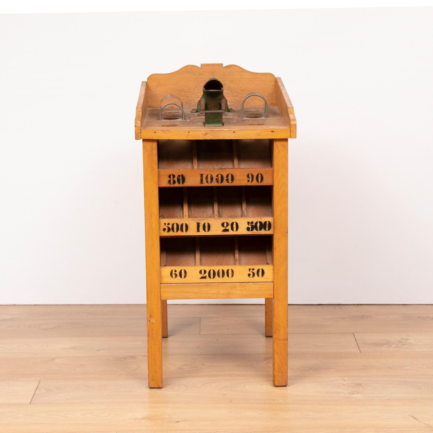French vintage frog game 'Jeux De La Grenouille'. The object of the game is to throw metal discs into various holes which then exit into the corresponding scoring channels. The frogs mouth being the best scoring.