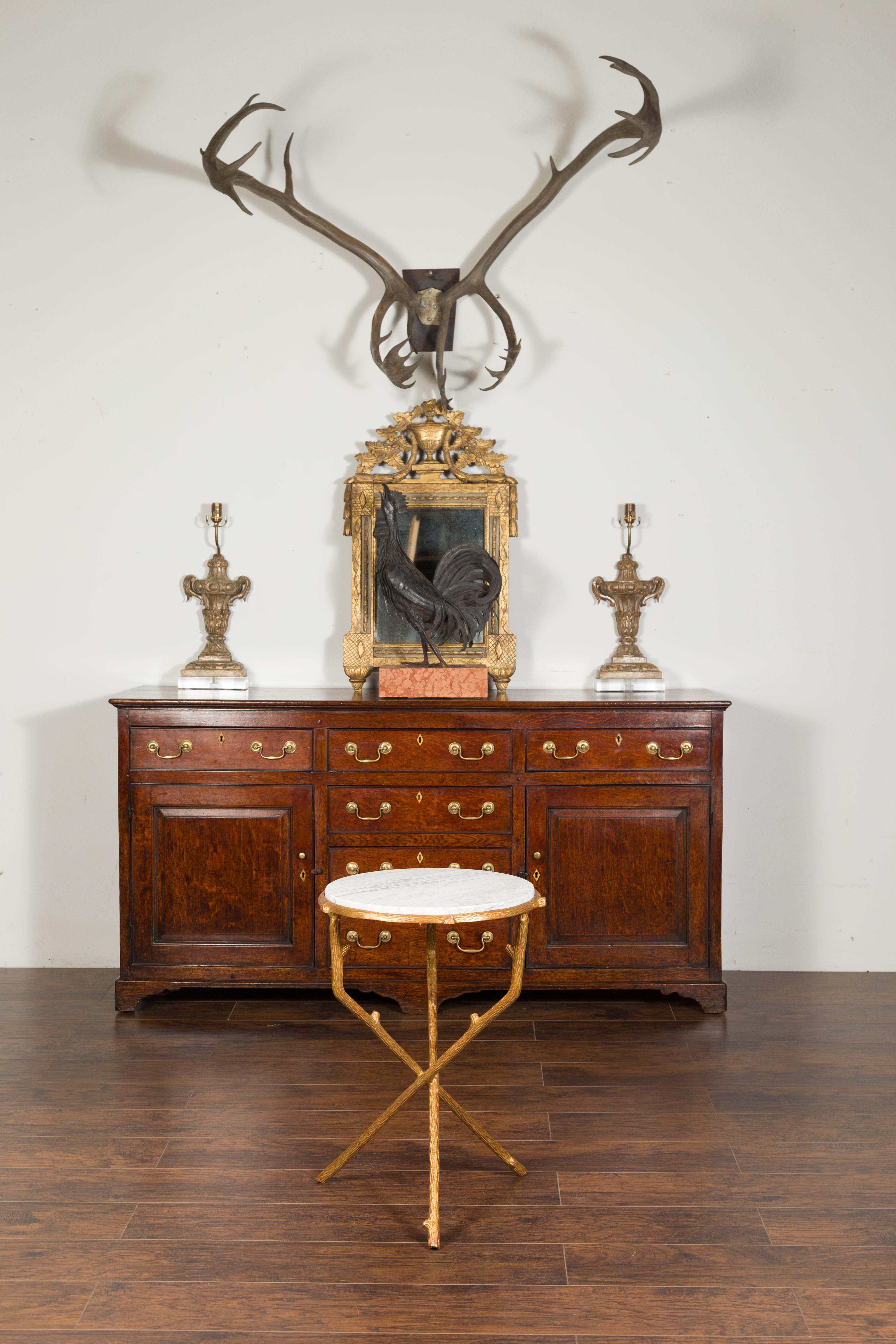 Table d'appoint en métal doré d'inspiration faux-bois, datant du milieu du 20e siècle, avec plateau en marbre blanc veiné. Créée en France au milieu du siècle dernier, cette table d'appoint est dotée d'un plateau circulaire en marbre blanc veiné